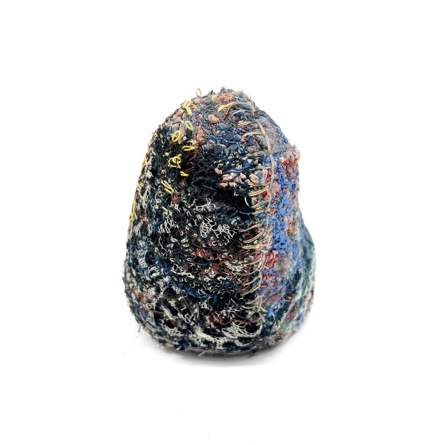 An embroidered rock, showcasing intricate stitched textures and a blend of diverse colored threads.