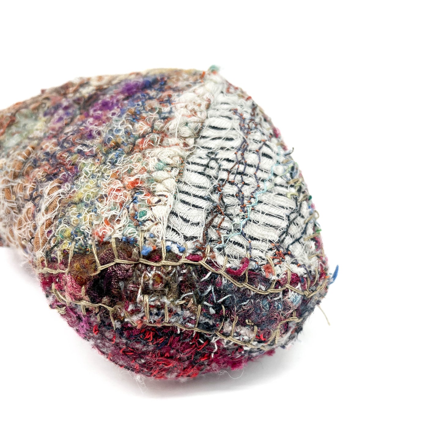 Textured textile art piece with dense, colorful embroidery and varied stitching techniques.