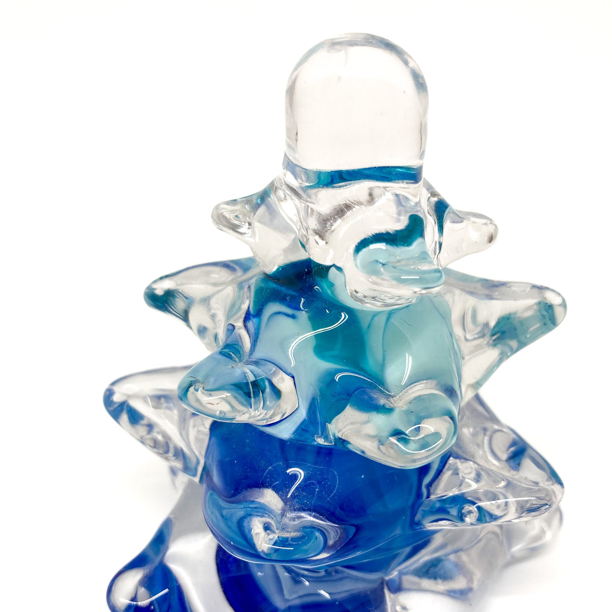 Close up of a clear glass Christmas tree with blue swirls.