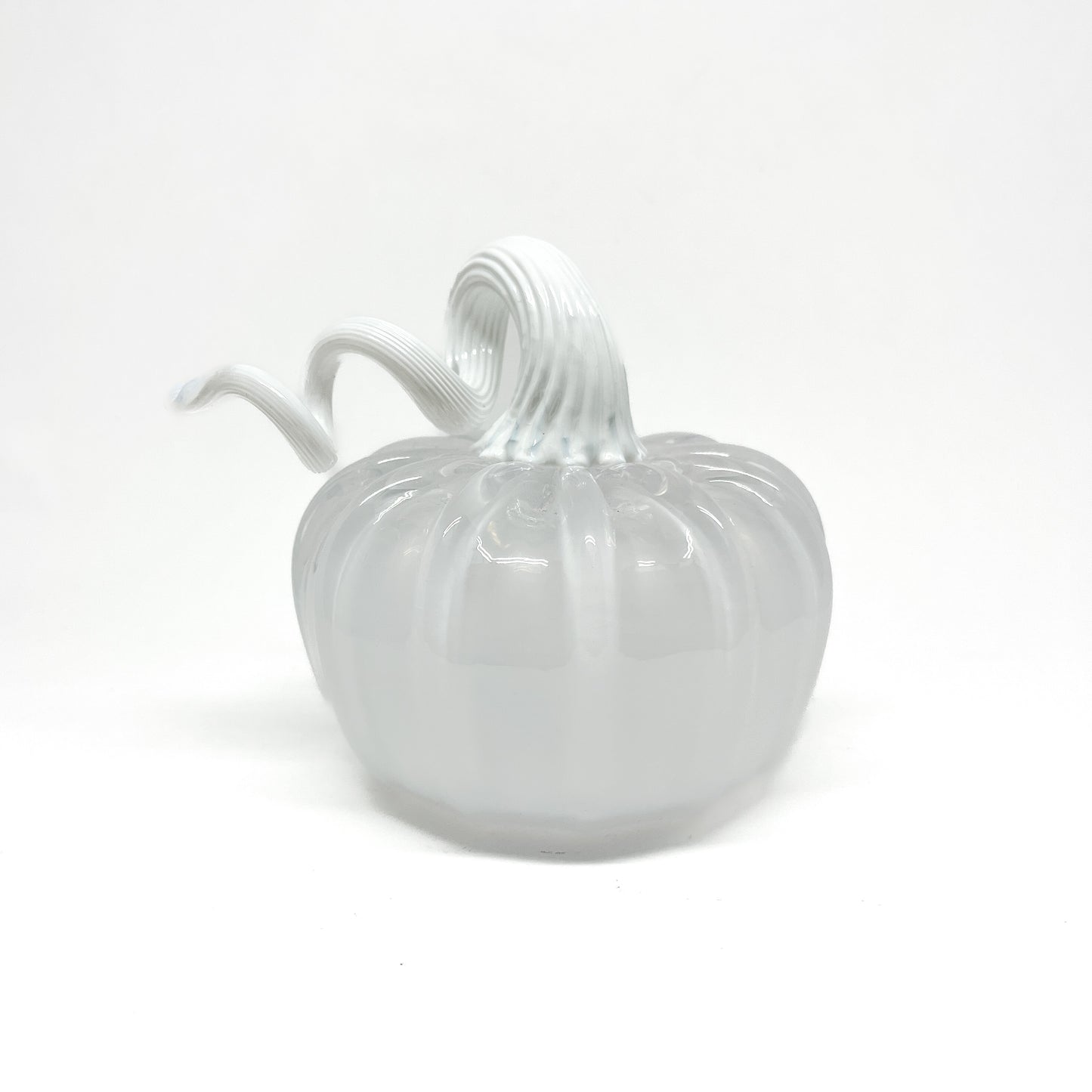 A white glass pumpkin with a curled, white glass stem.