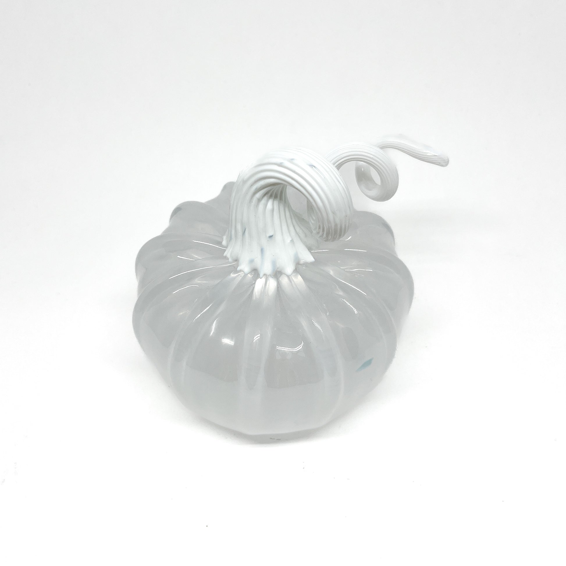 A white glass pumpkin with a curled, white glass stem.