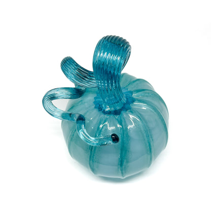 A light blue glass pumpkin with a curled, grooved light blue glass stem.