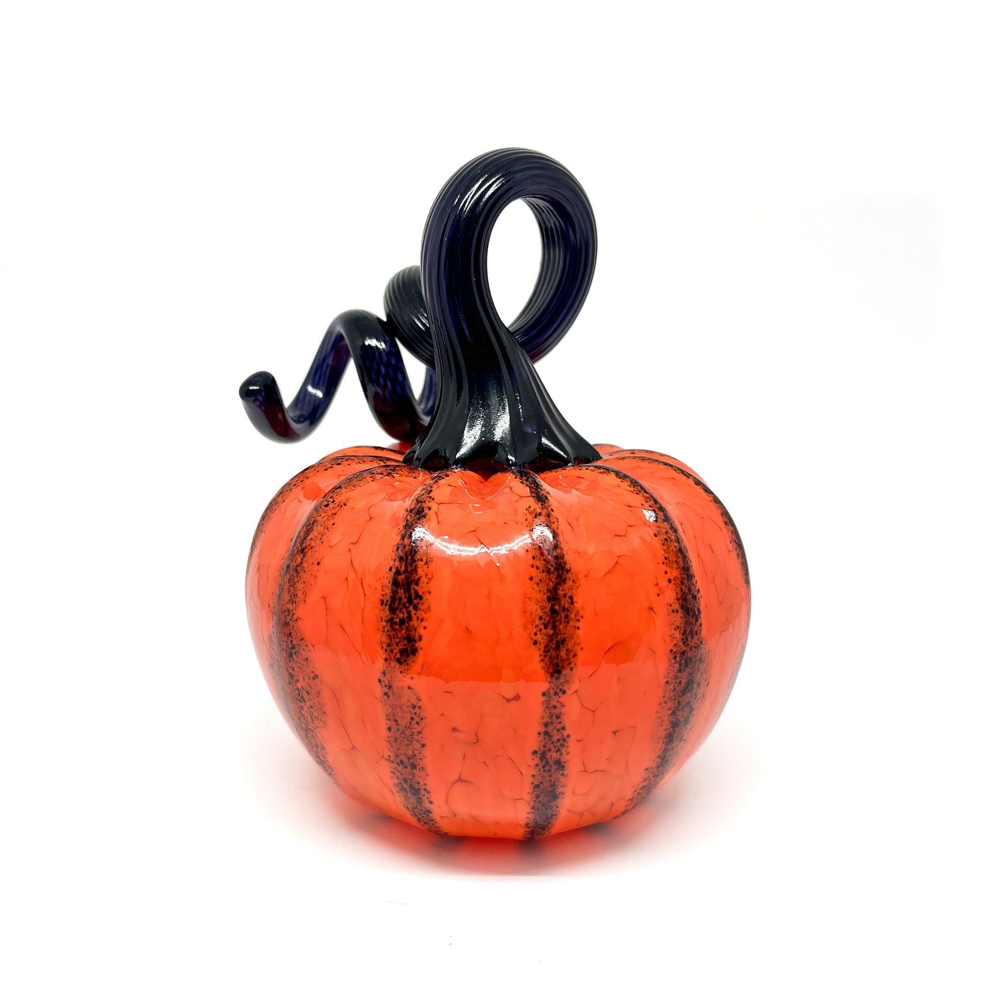 An orange glass pumpkin with black stripes and a curled, dark blue glass stem.