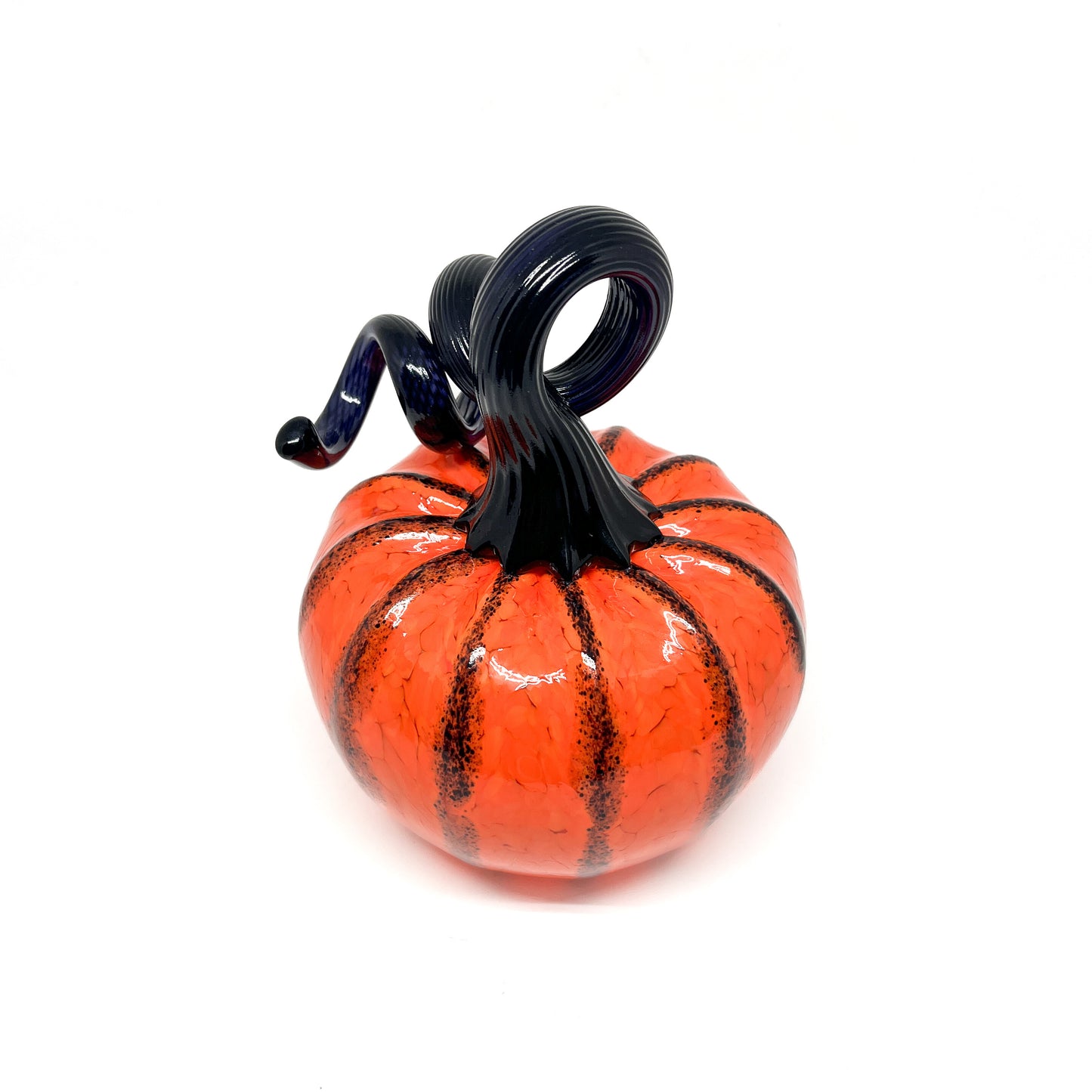 An orange glass pumpkin with black stripes and a curled, dark blue glass stem.