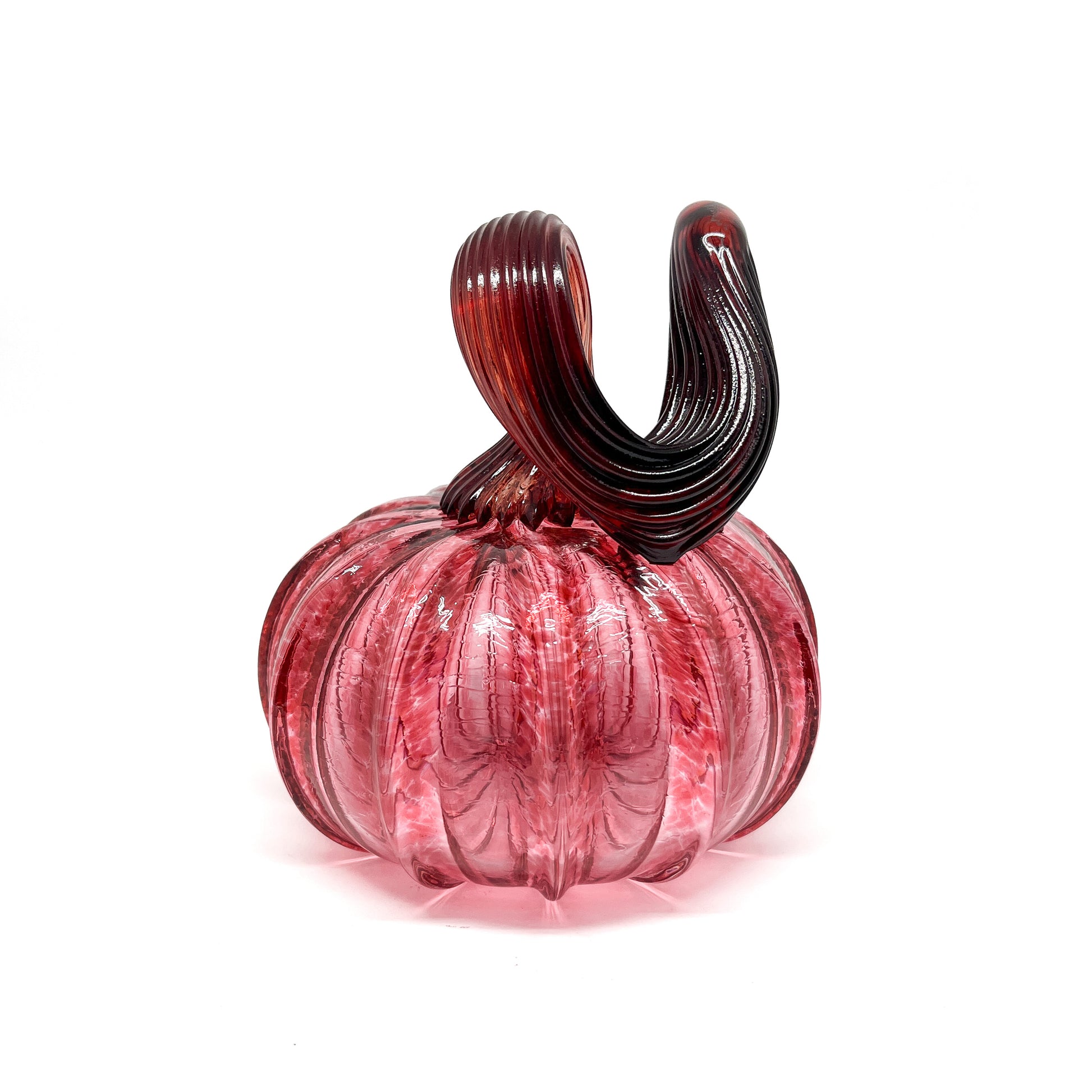 A pink glass pumpkin with a curled, dark red glass stem.