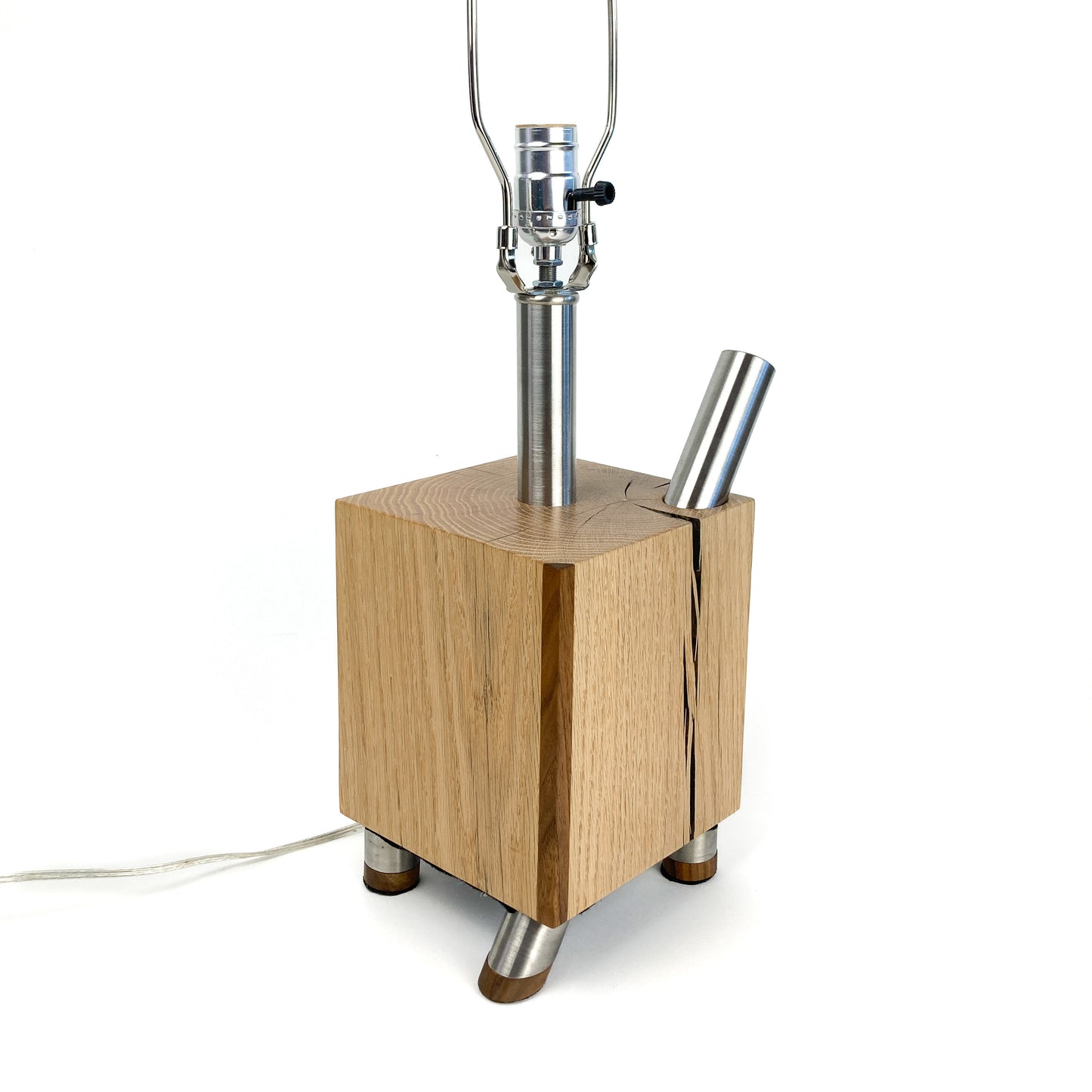 Lamp base: light wood block, metal feet, two metal rods, socket and harp, no shade.