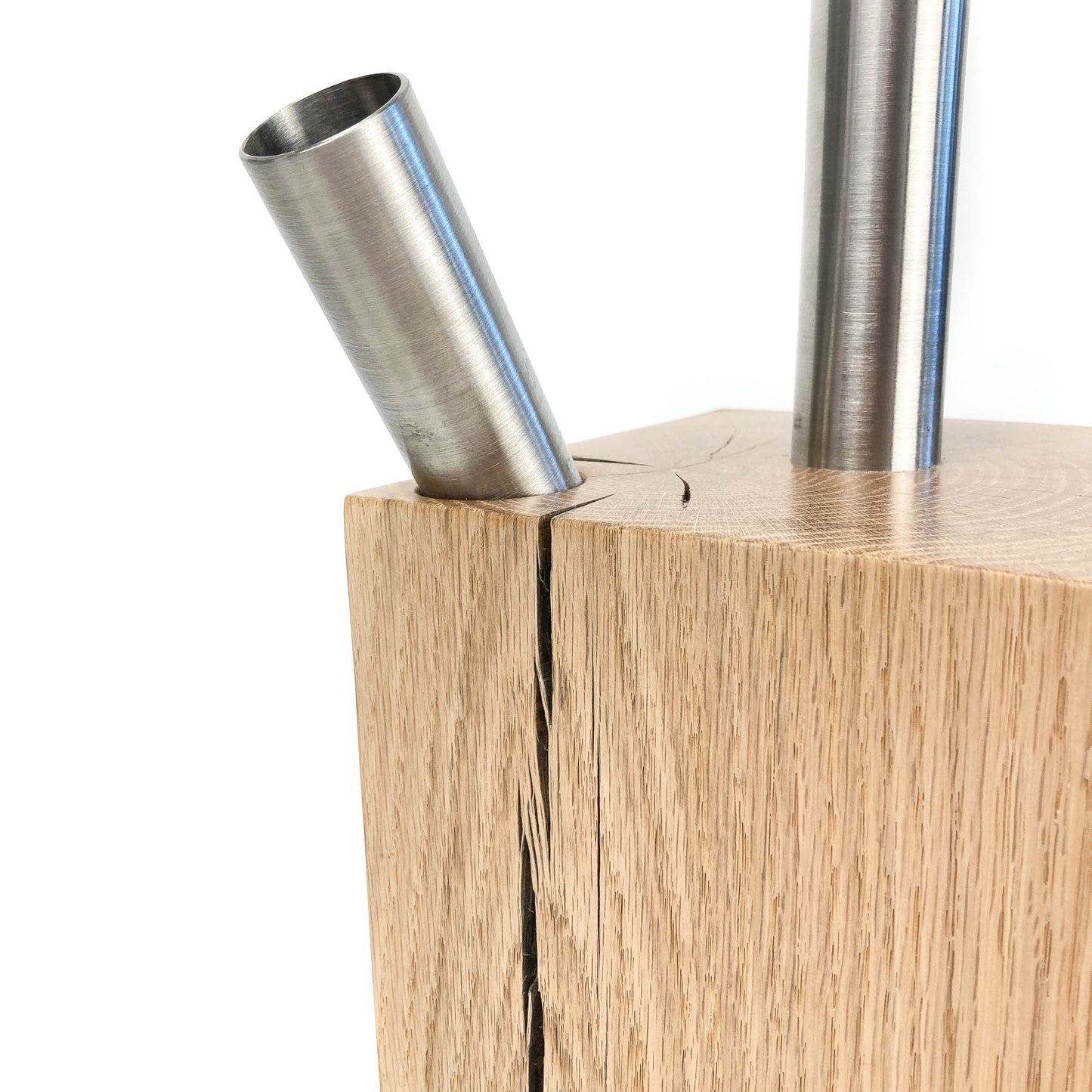 Lamp base detail: light wood block with two metal rods, one angled.