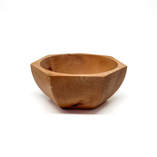 A light-colored, eight-sided wooden bowl with visible grain and a smooth, carved interior. The bowl has a shallow depth.
