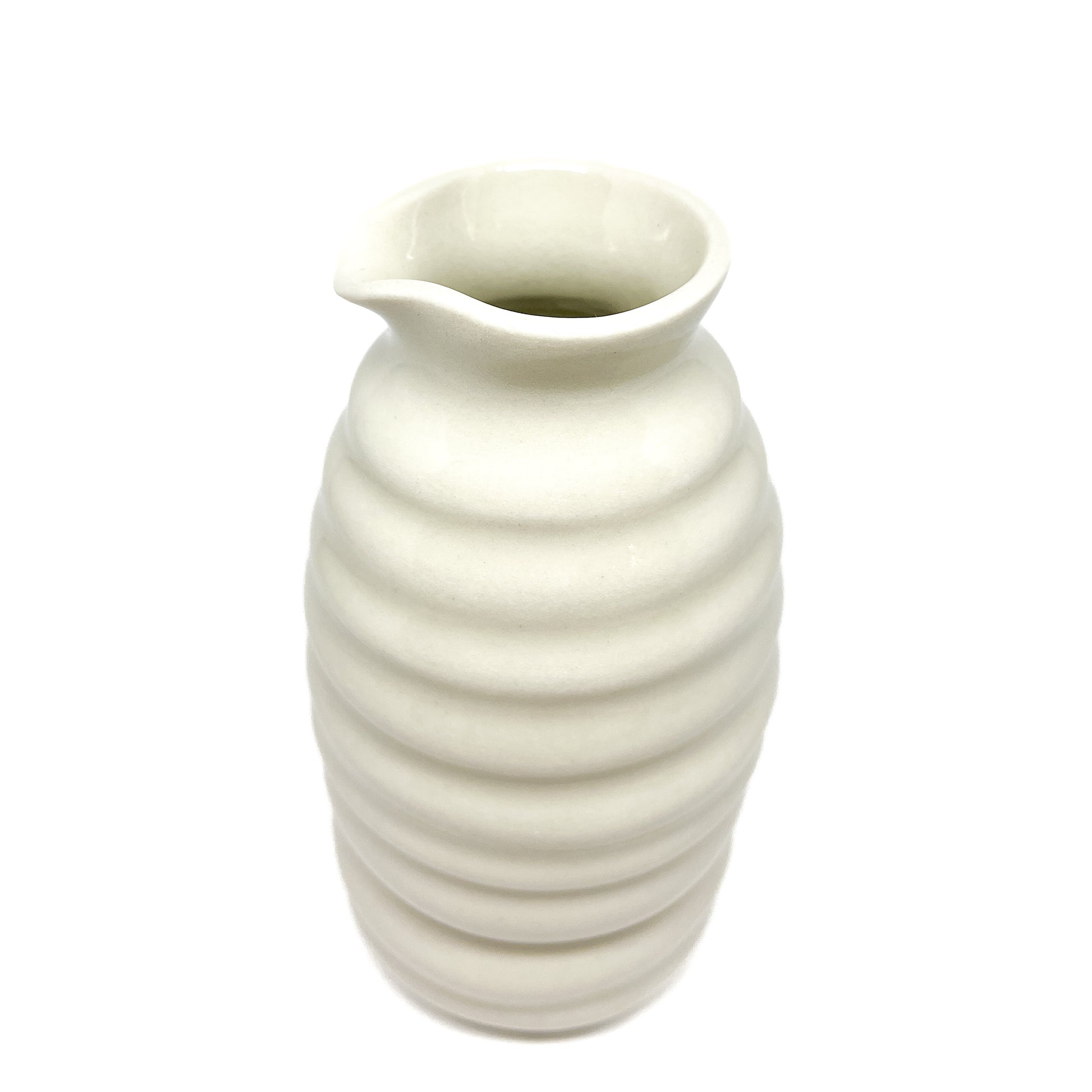 A ceramic HULL Beehive Urn Vase with stacked horizontal ridges and a slightly flared, asymmetrical rim.