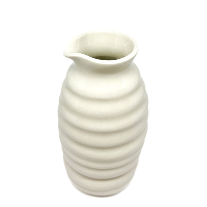 A ceramic HULL Beehive Urn Vase with stacked horizontal ridges and a slightly flared, asymmetrical rim.