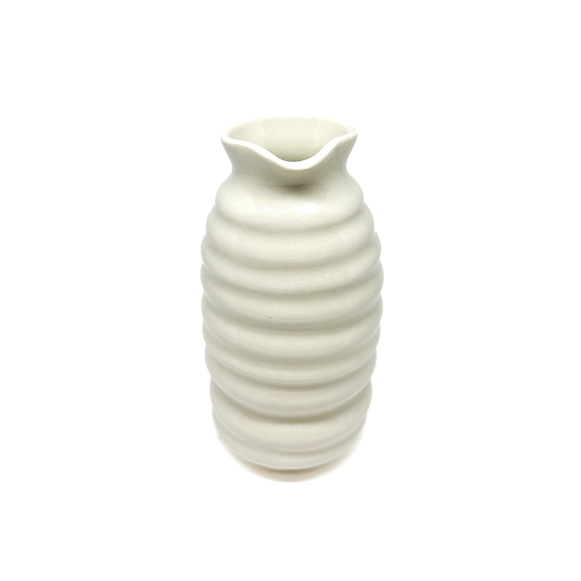 A ceramic vase with a beehive-like form, featuring stacked horizontal ridges and a wavy, flared opening at the top.