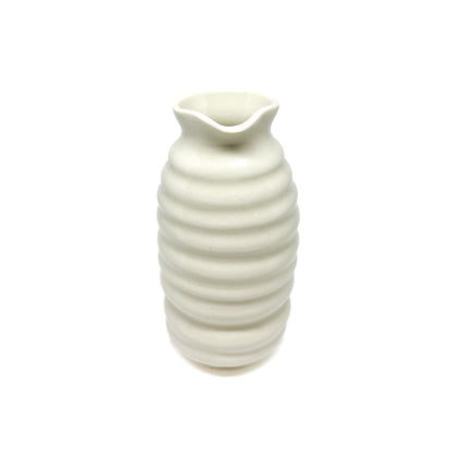 A ceramic vase with a beehive-like form, featuring stacked horizontal ridges and a wavy, flared opening at the top.