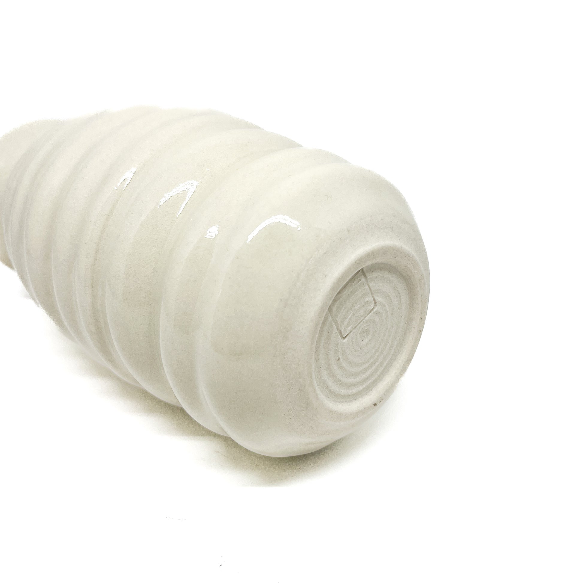 Bottom view of a ceramic Haeger Beehive Swirl Vase, showing concentric circular markings and a small, rectangular maker's mark. The vase has horizontal ridges.