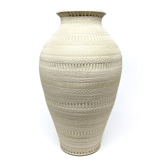 A large, off-white ceramic vase with intricate, textured horizontal bands and a narrow neck.