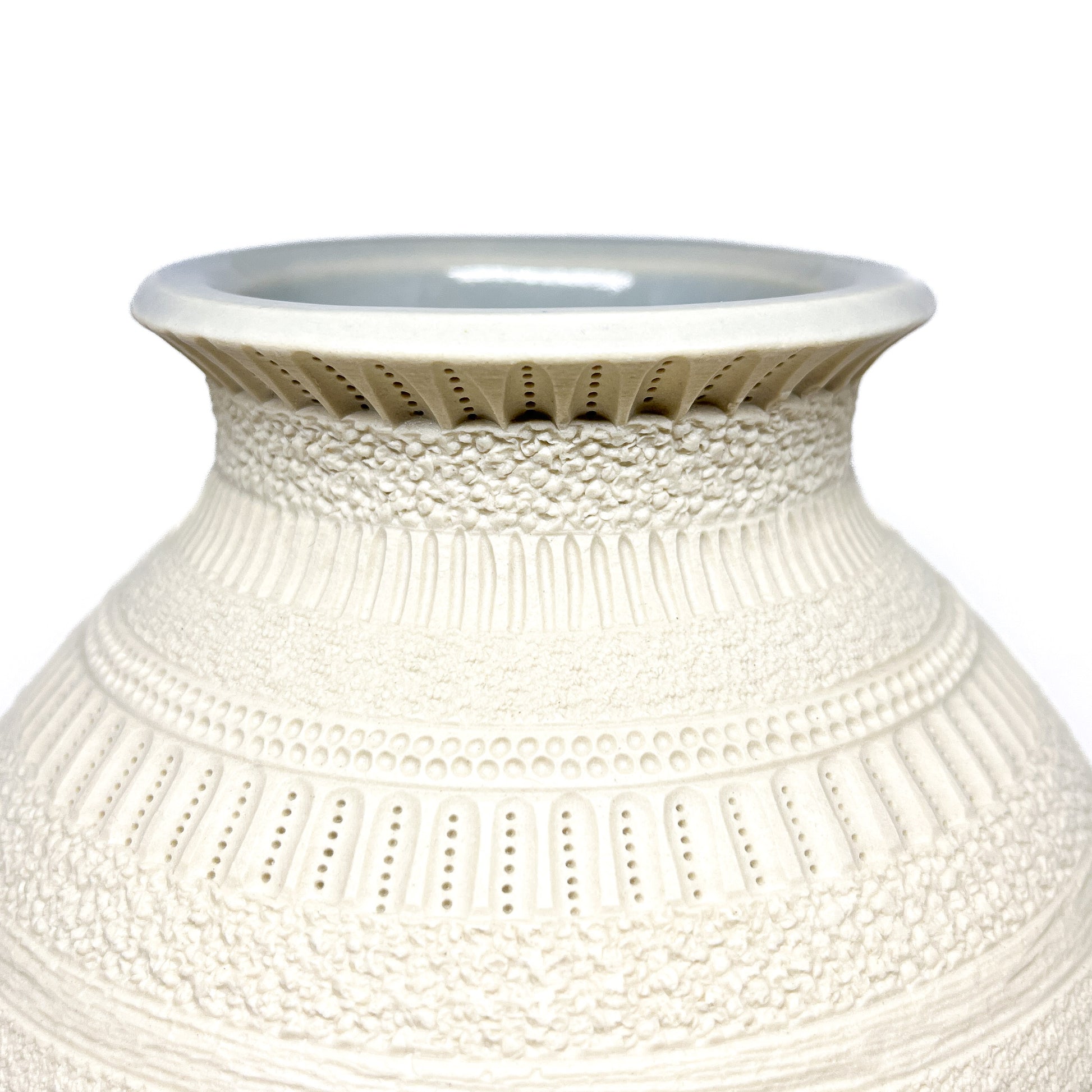Close-up of the textured neck and rim of a large Diatom Vase, showing intricate patterns.