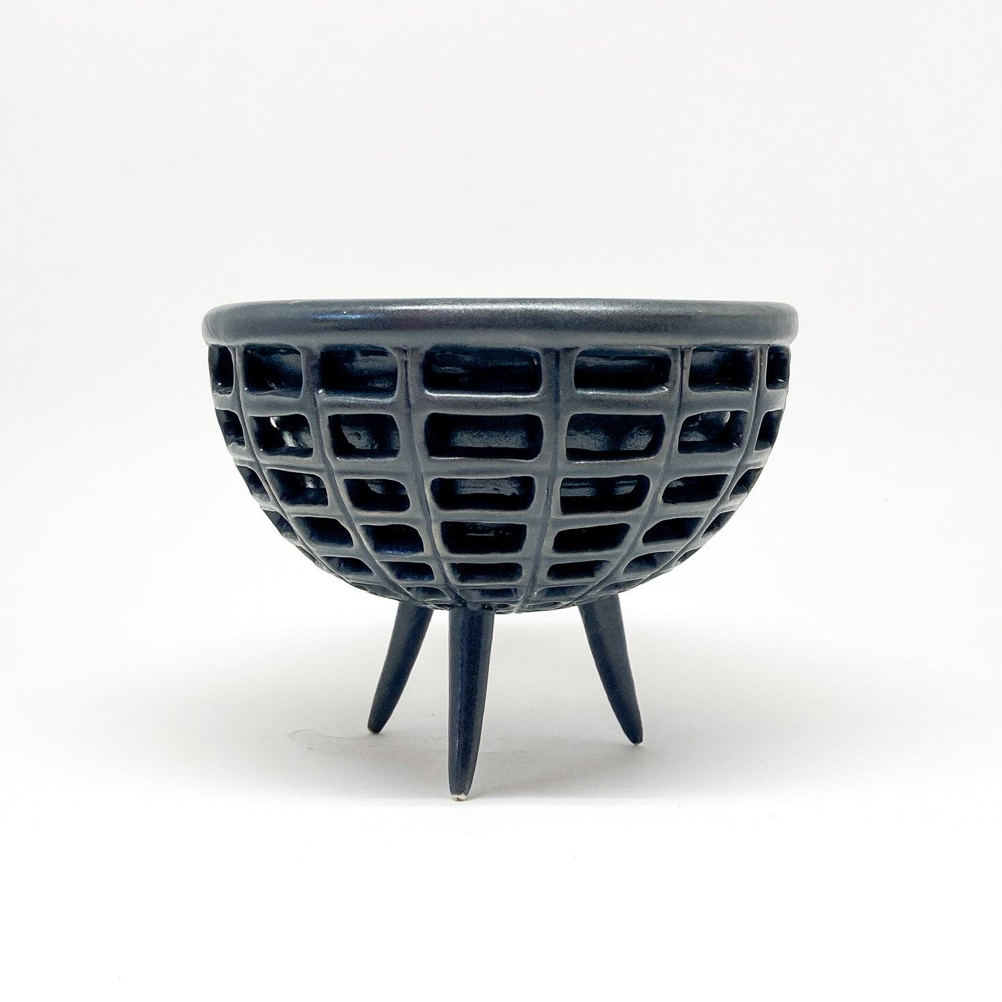 A black, double-walled diatom bowl with a lattice design and three small legs.