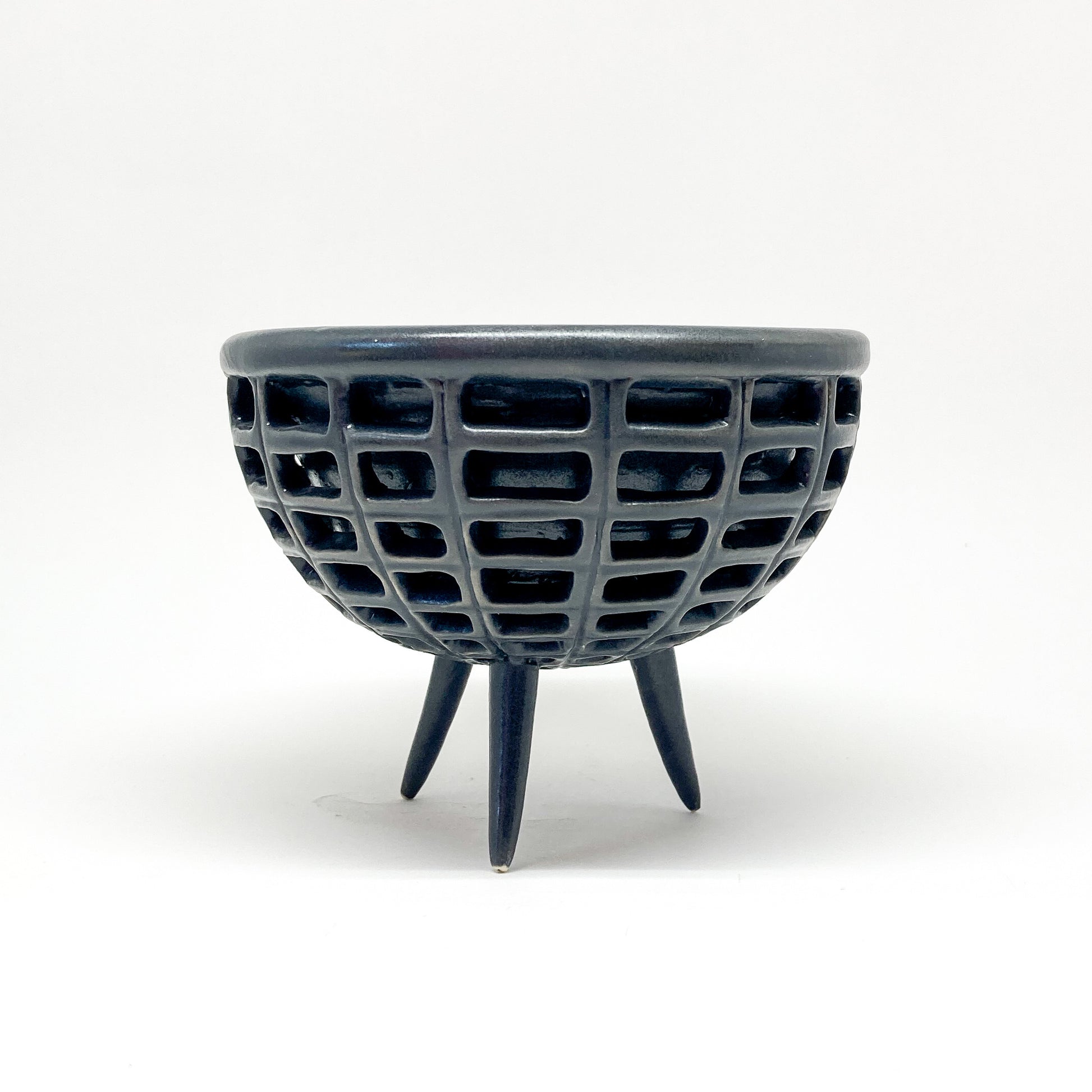 A black, double-walled diatom bowl with a lattice design and three small legs.