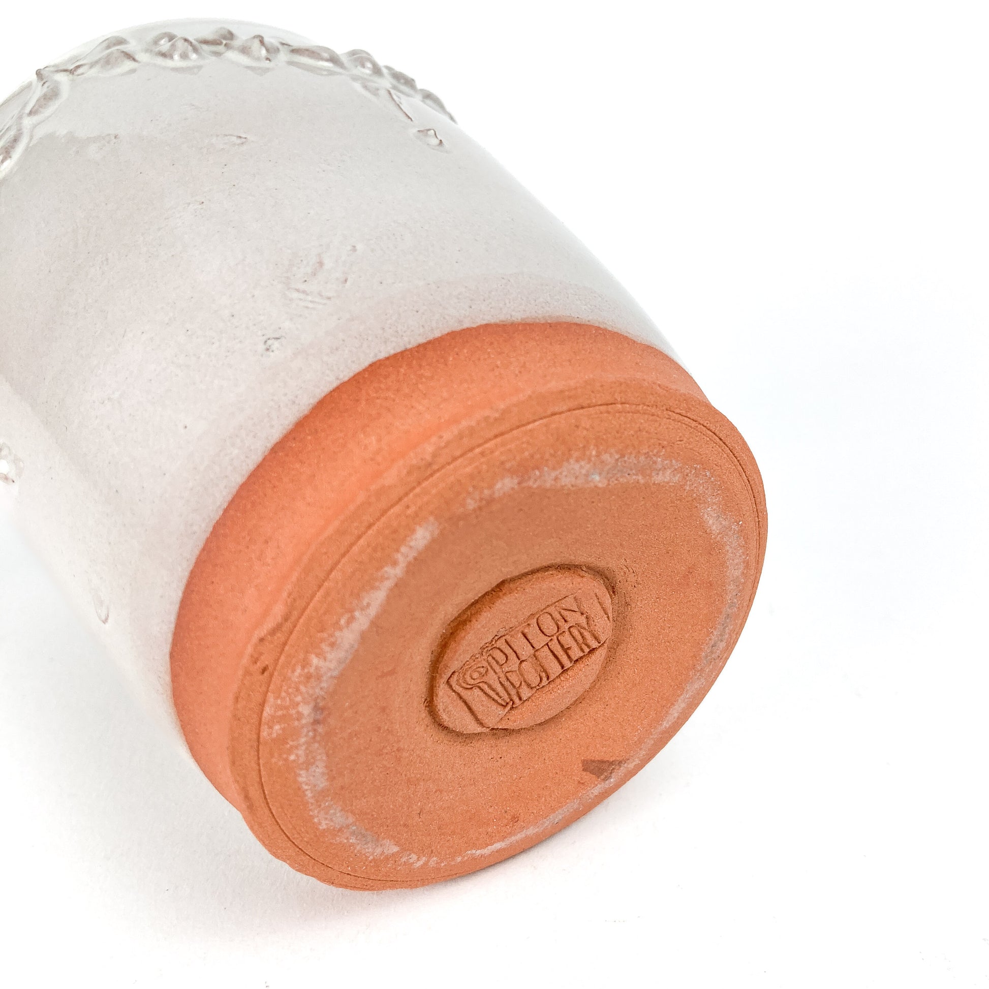 Bottom view of a ceramic tumbler revealing its unglazed base and the "Cotton Pottery" maker's mark.