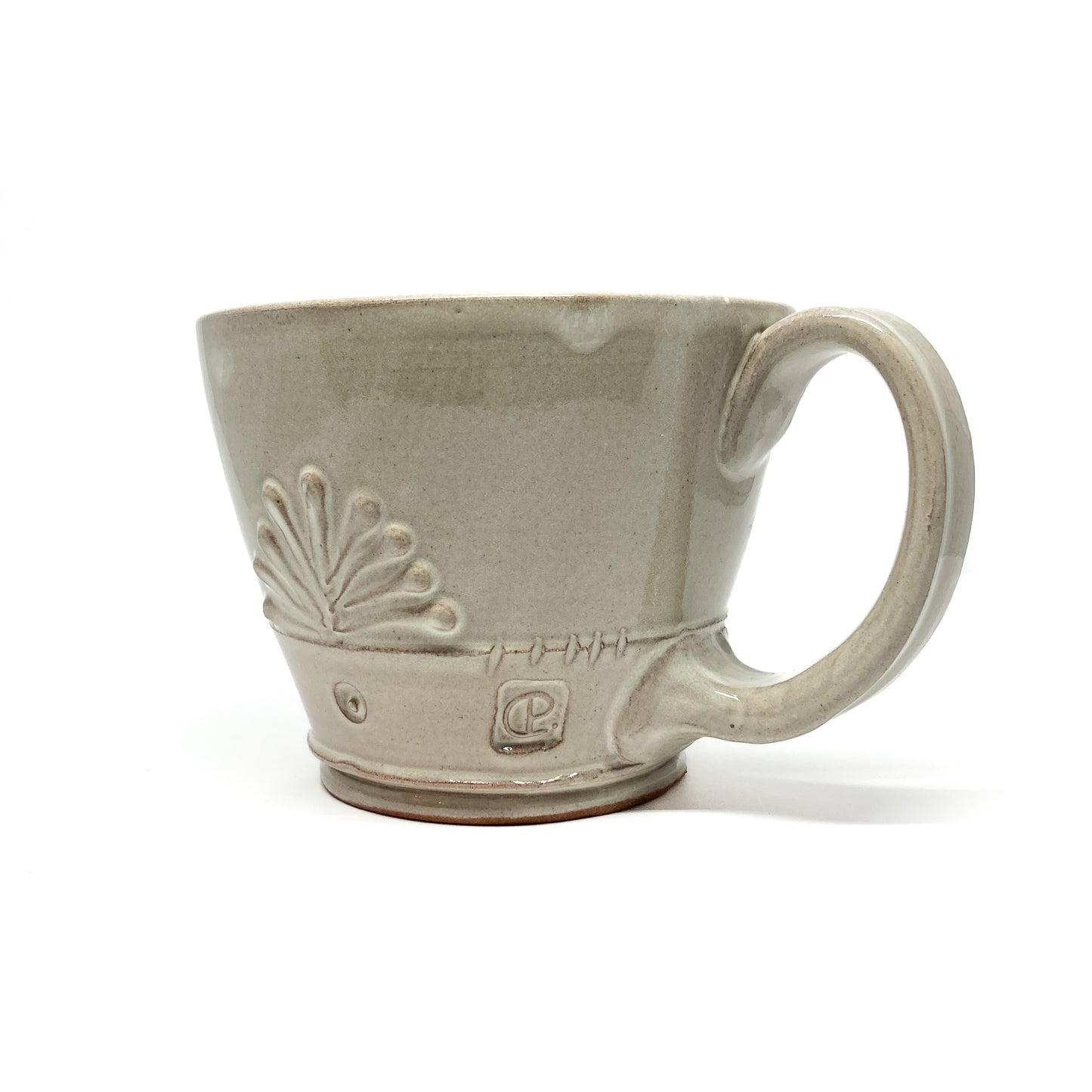 Speckled, glazed ceramic latte mug with an embossed, stylized floral design and a circular maker's mark.