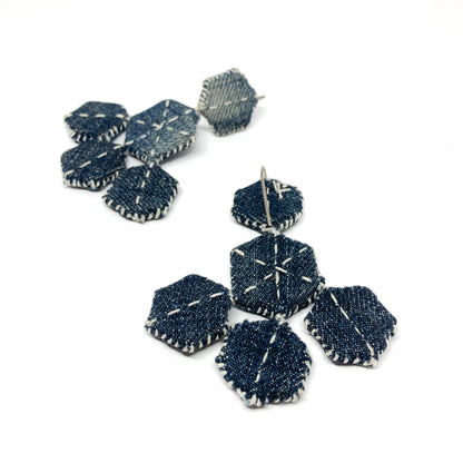 "Patched Chandelier" earrings: denim hexagons layered and stitched with white thread, showcasing their unique design.