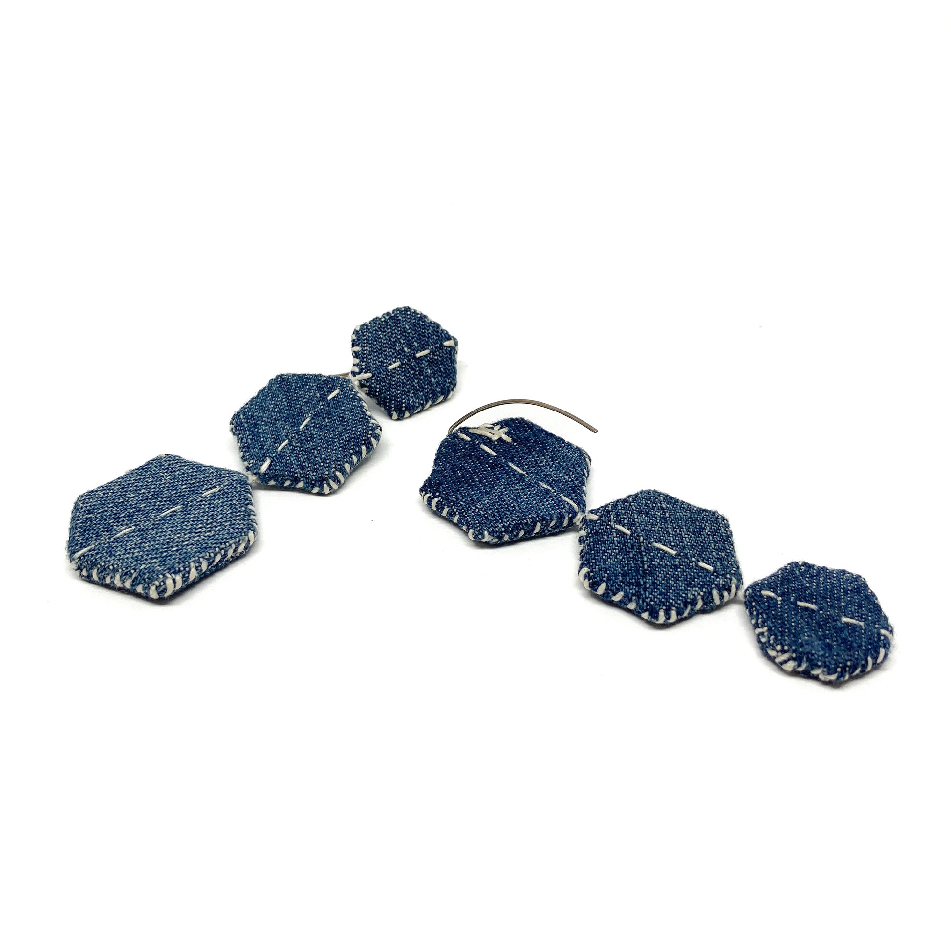 Louise Perrone "Patched Trio" earrings: two individual earrings, each with three connected denim hexagonal patches and white stitching.