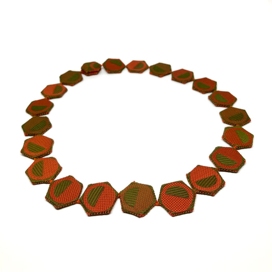 A necklace made of connected hexagonal pieces with alternating patterns.