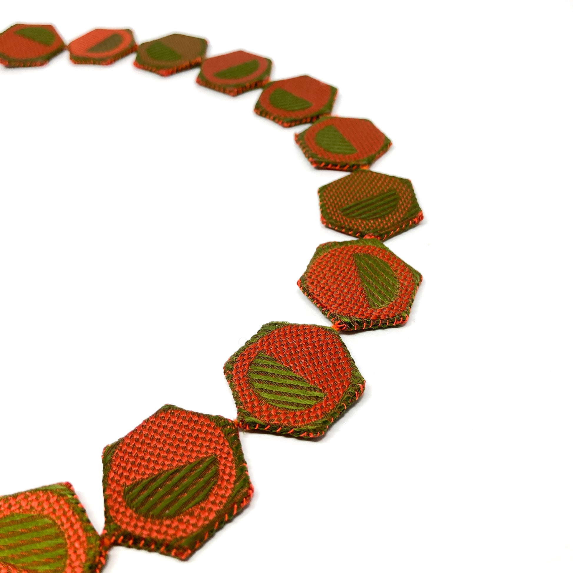 Close-up of a ReAuthorized Border Necklace, showcasing the textured, patterned hexagonal links.