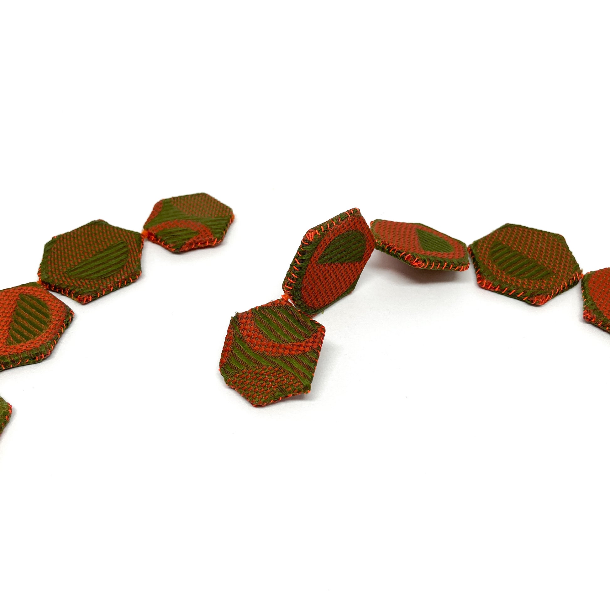 A section of the ReAuthorized Border Necklace, showing the individual patterned and textured hexagonal components linked together.