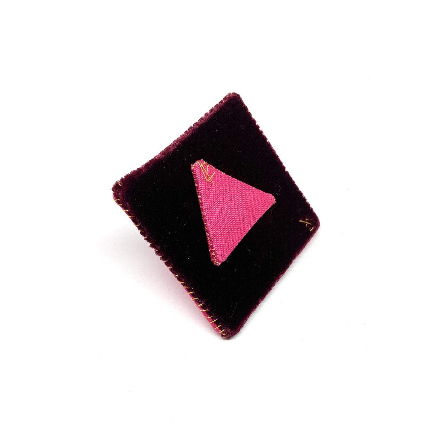 Back of a "Flagged Elevensies" brooch featuring a triangular pin attachment on a square backing.