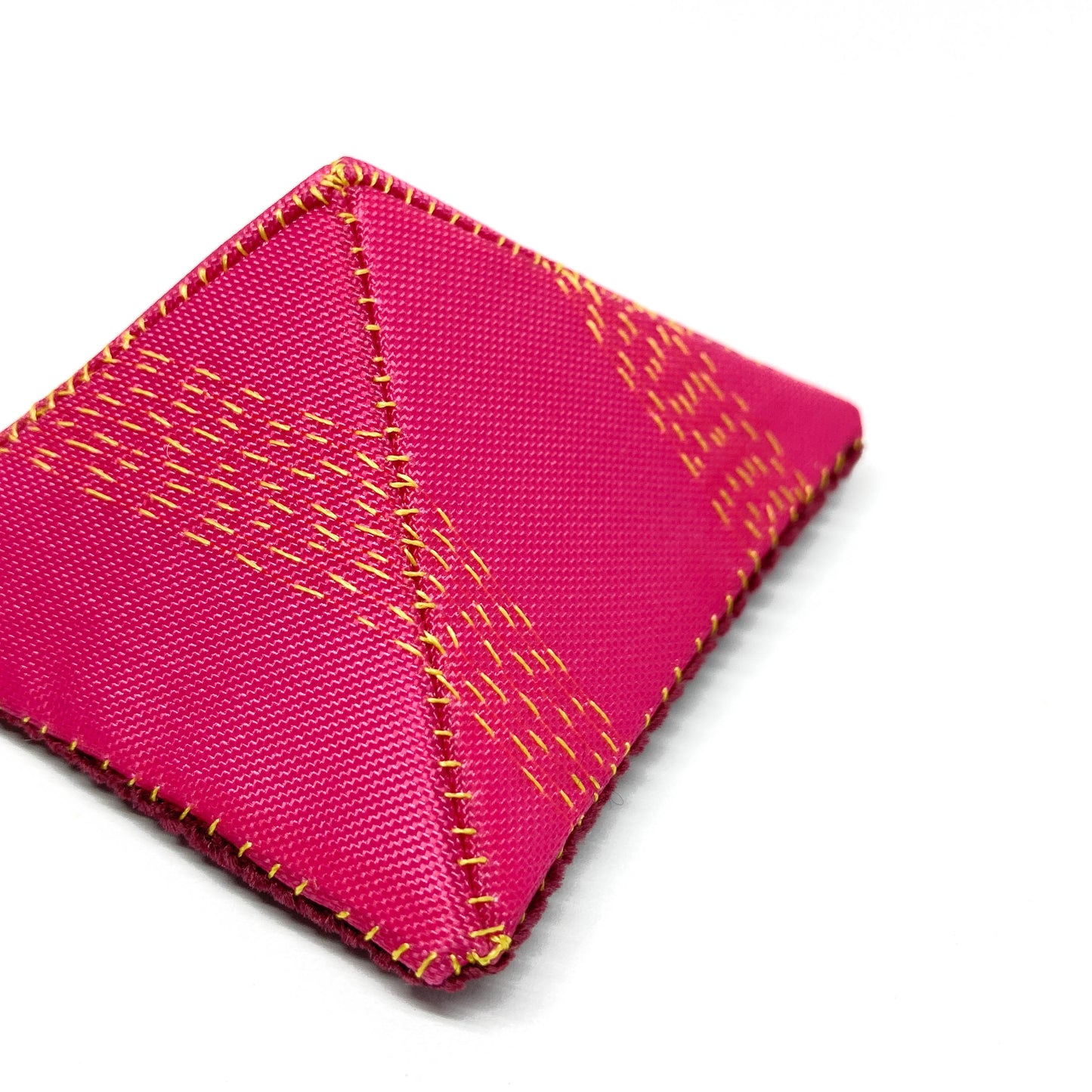 Close-up of a "Flagged Elevensies" brooch highlighting the fabric texture and stitched details.
