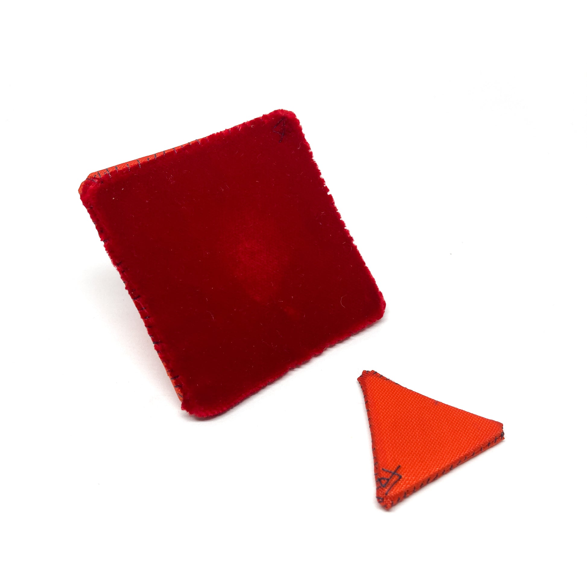 Orange "Flagged Elevensies" brooch with the triangular flag separated from the square pin backing.