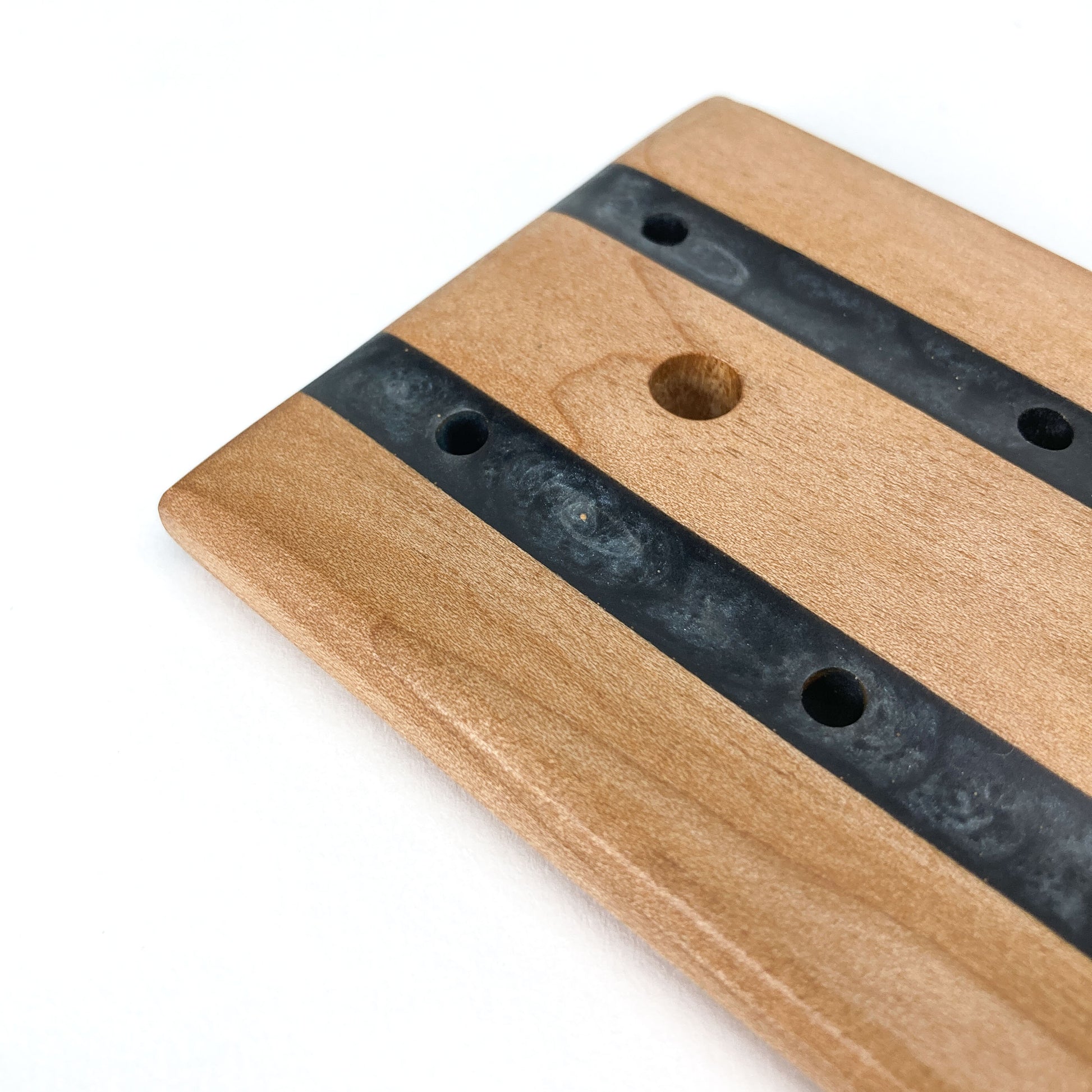 Close-up of a Tuxedo Soap Tray showing resin inlays and precision-drilled drainage holes.