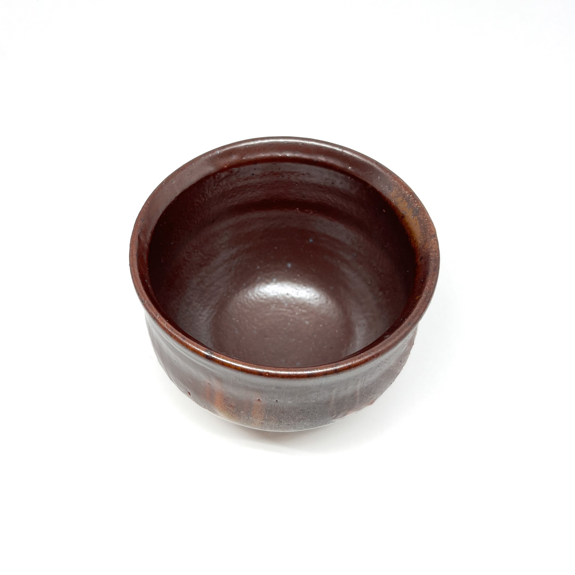 A rustic, dark brown wood-fired tea bowl with subtle variations in texture and glaze.