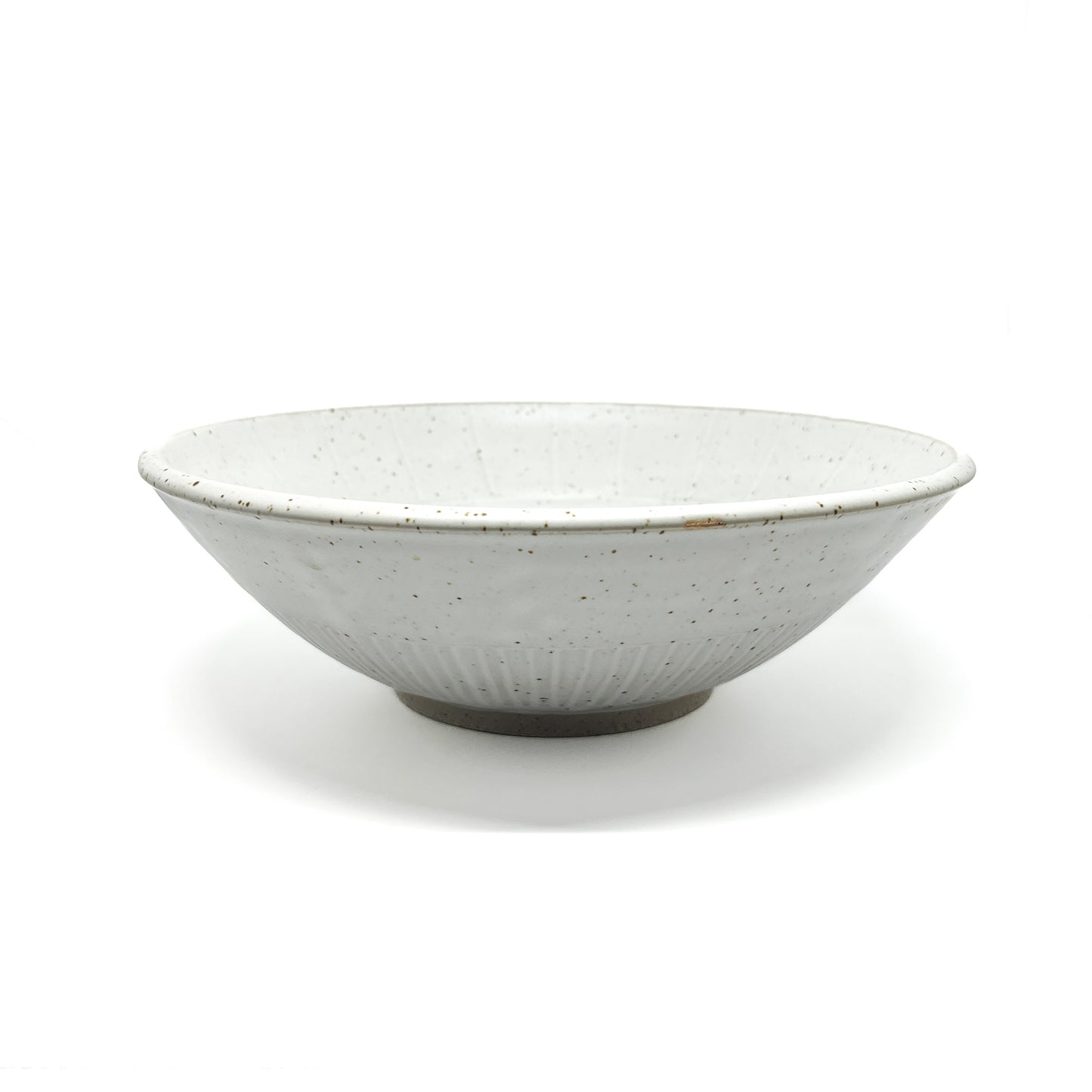 A speckled light-toned ceramic bowl with subtle vertical ridges and a visible unglazed base.