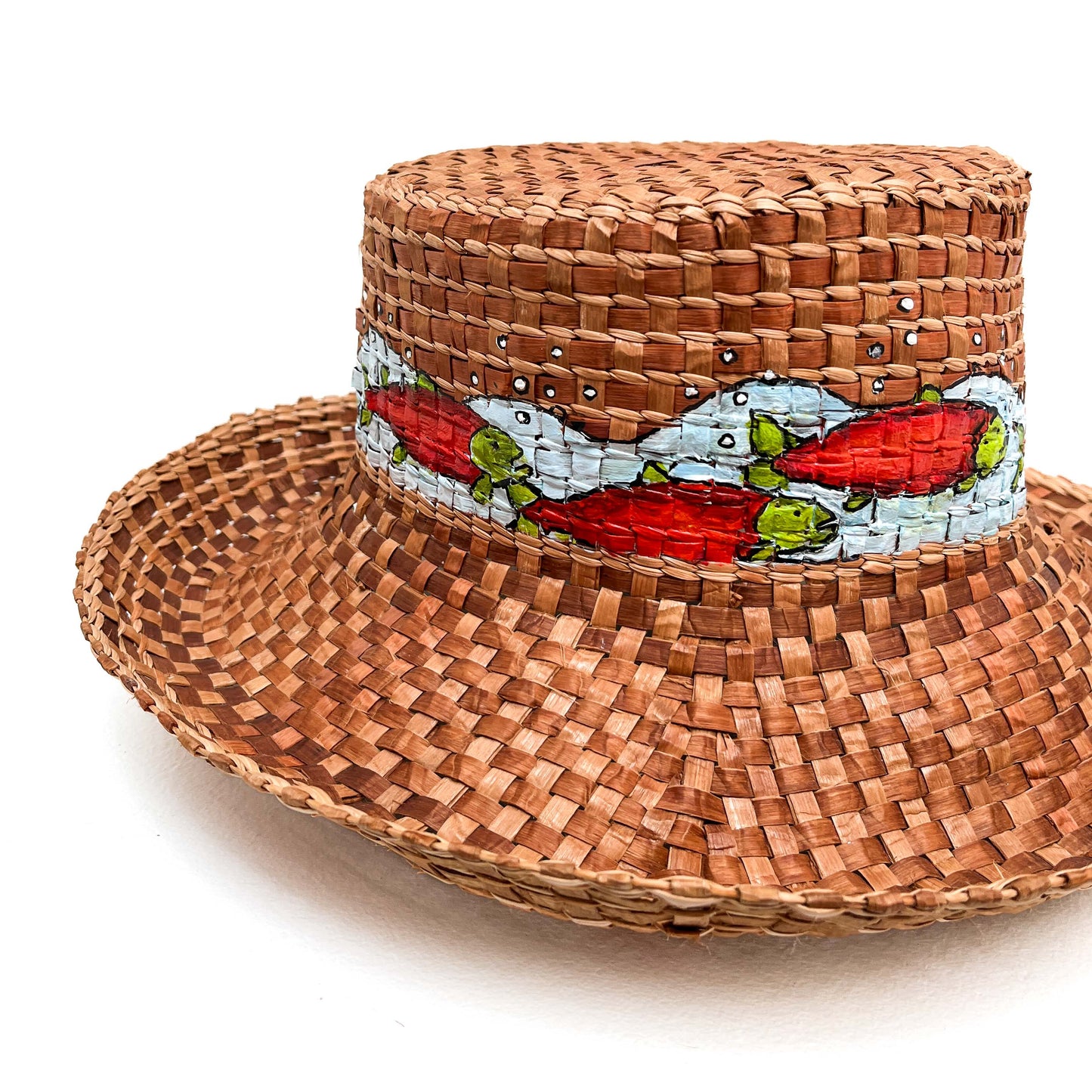 A woven hat with a cylindrical crown and wide brim, featuring a band with painted fish.