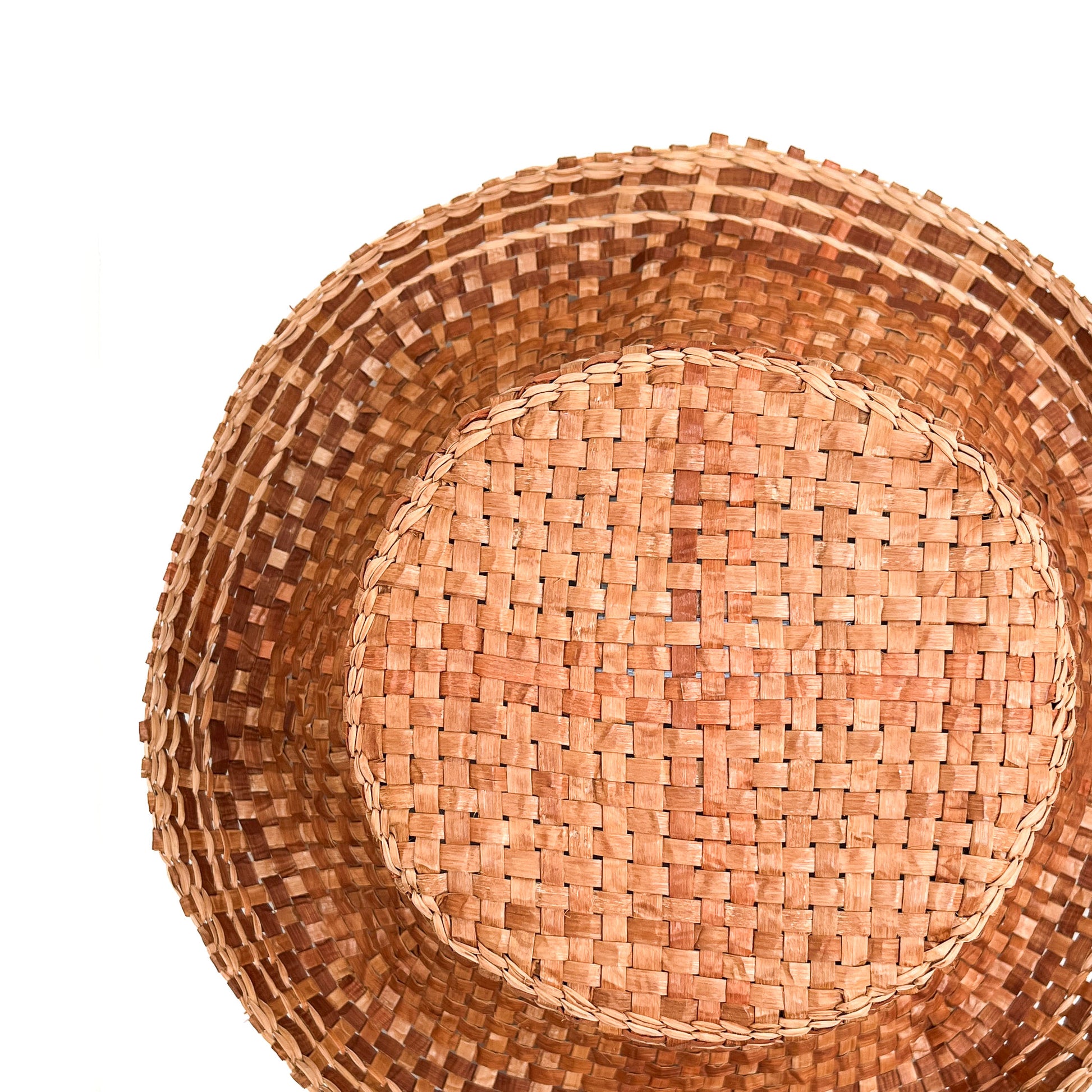 A top-down view of a woven hat, showing the crown and wide brim's intricate weave.