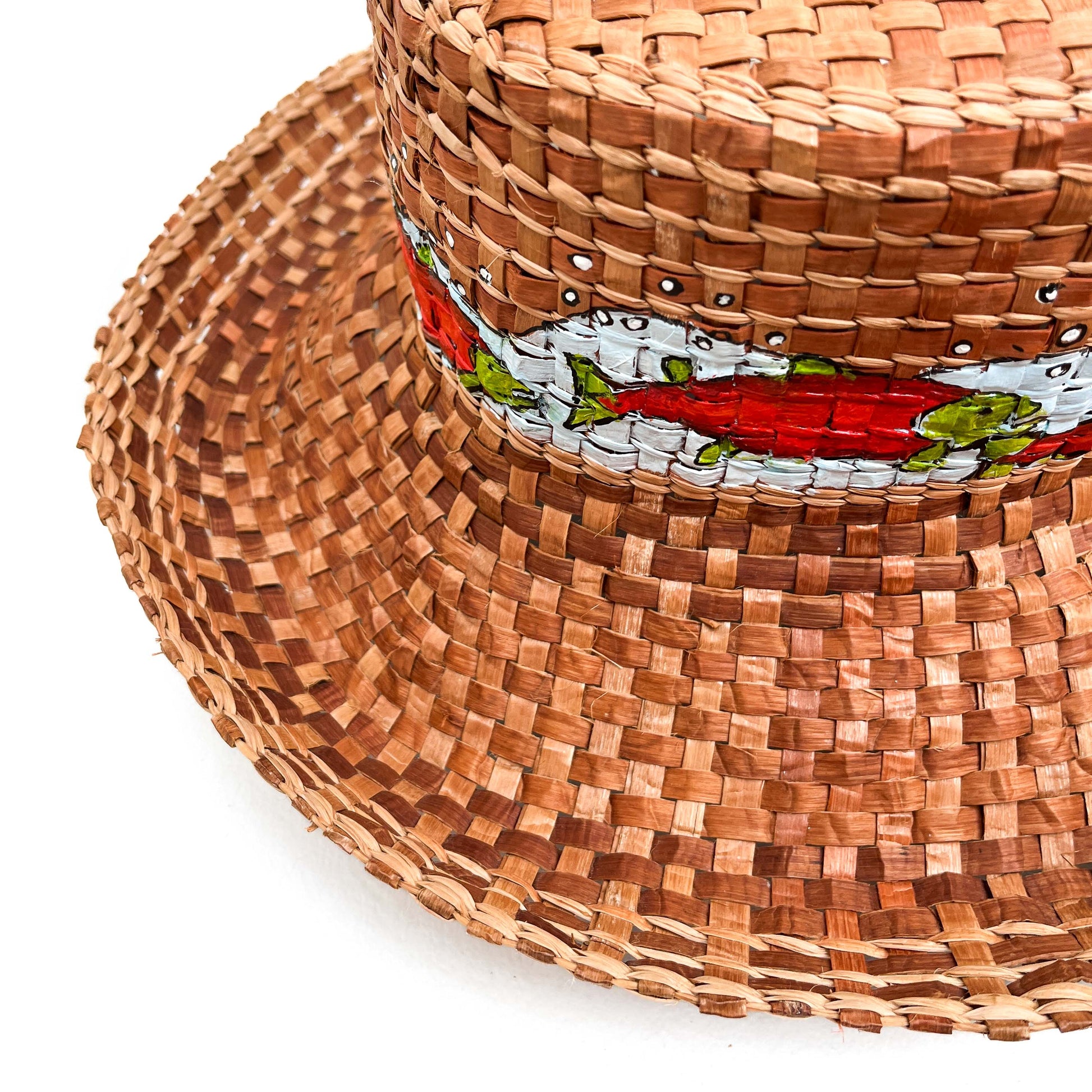 A woven hat with a cylindrical crown and wide brim, featuring a band with painted fish.