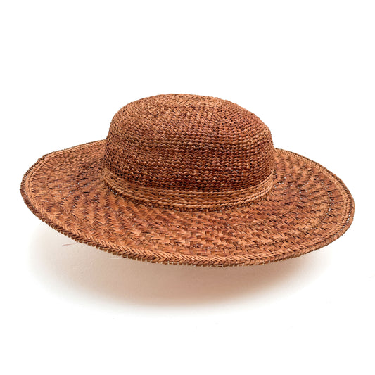 A wide-brimmed woven hat with a rounded crown, featuring a band around the base.