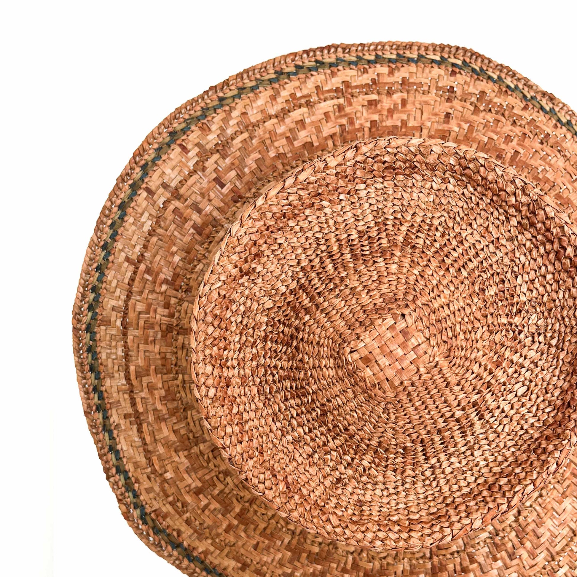 A top-down view of a woven hat, showing the crown, wide brim, and a green band around the edge.
