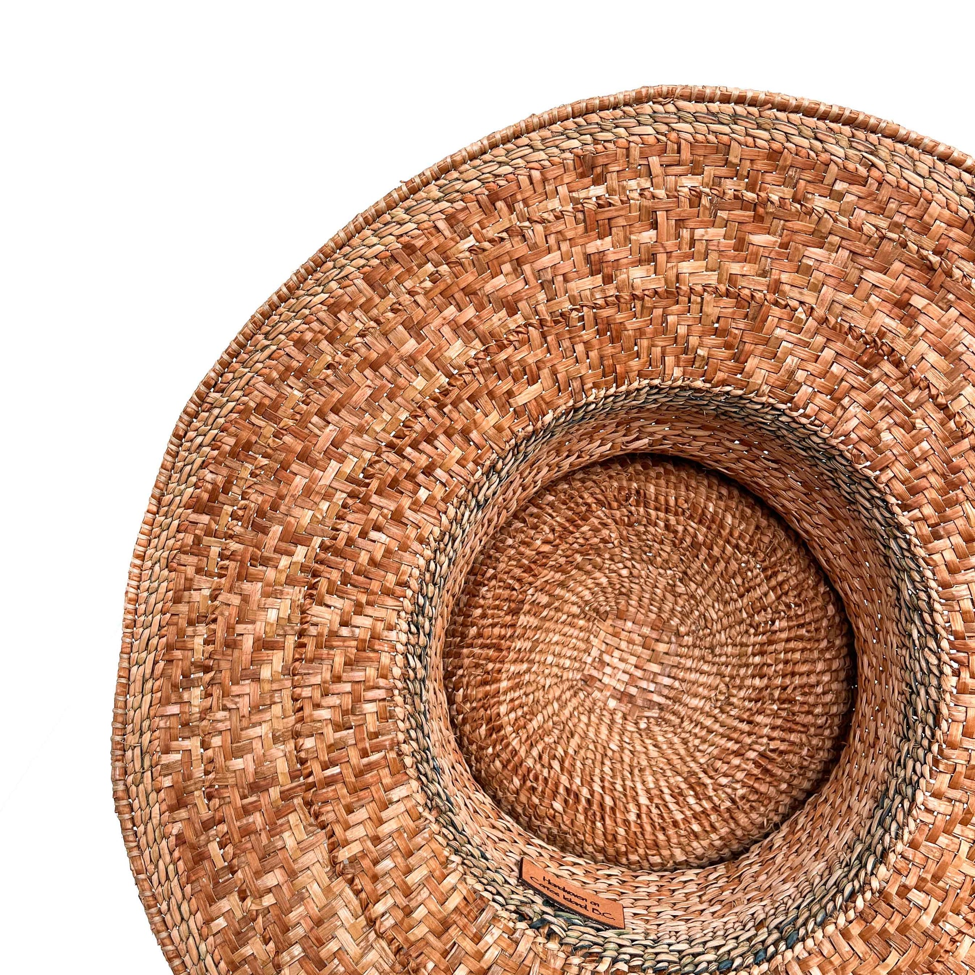 A top-down, angled view of the inside of a woven hat, showing the texture and a small label.