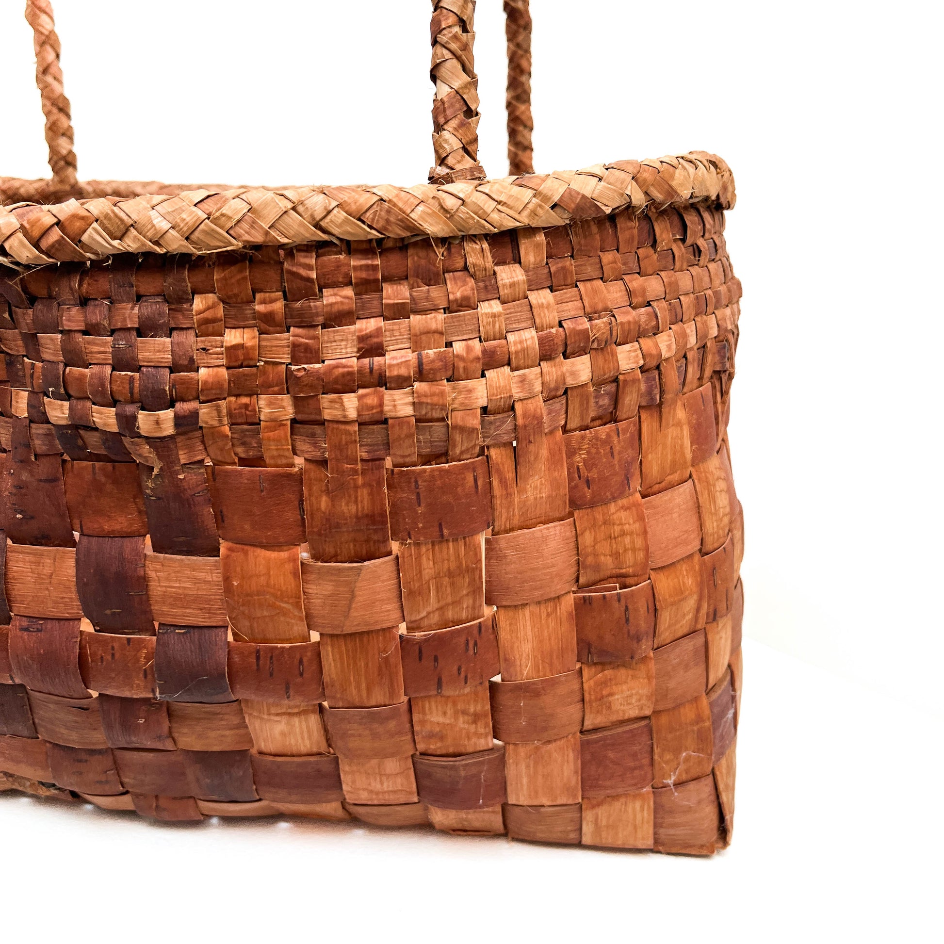 A close-up of a rectangular woven basket with handles, showing the checkered pattern and texture.