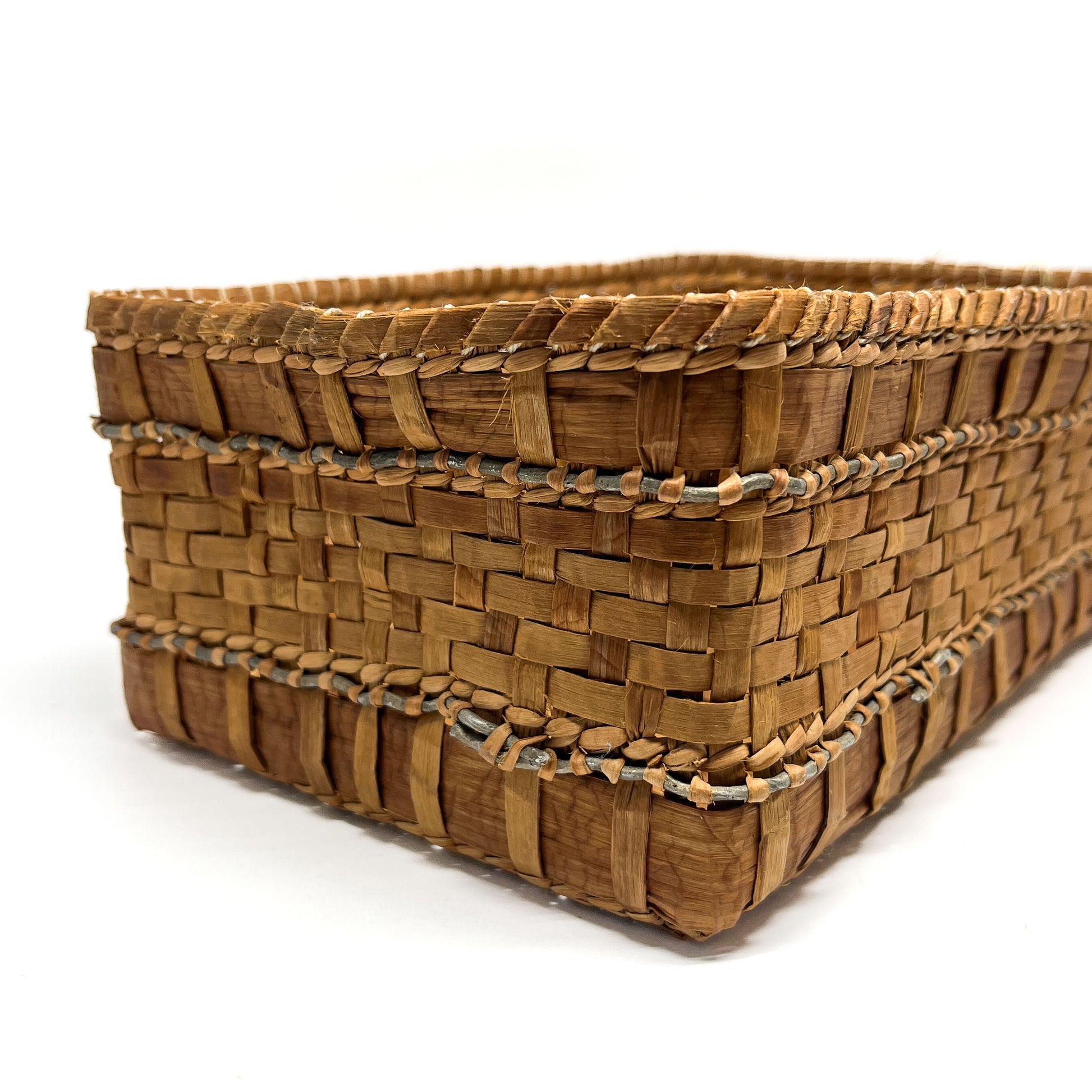 A close-up of a rectangular woven basket with brown and tan checkered patterns and gray accents.