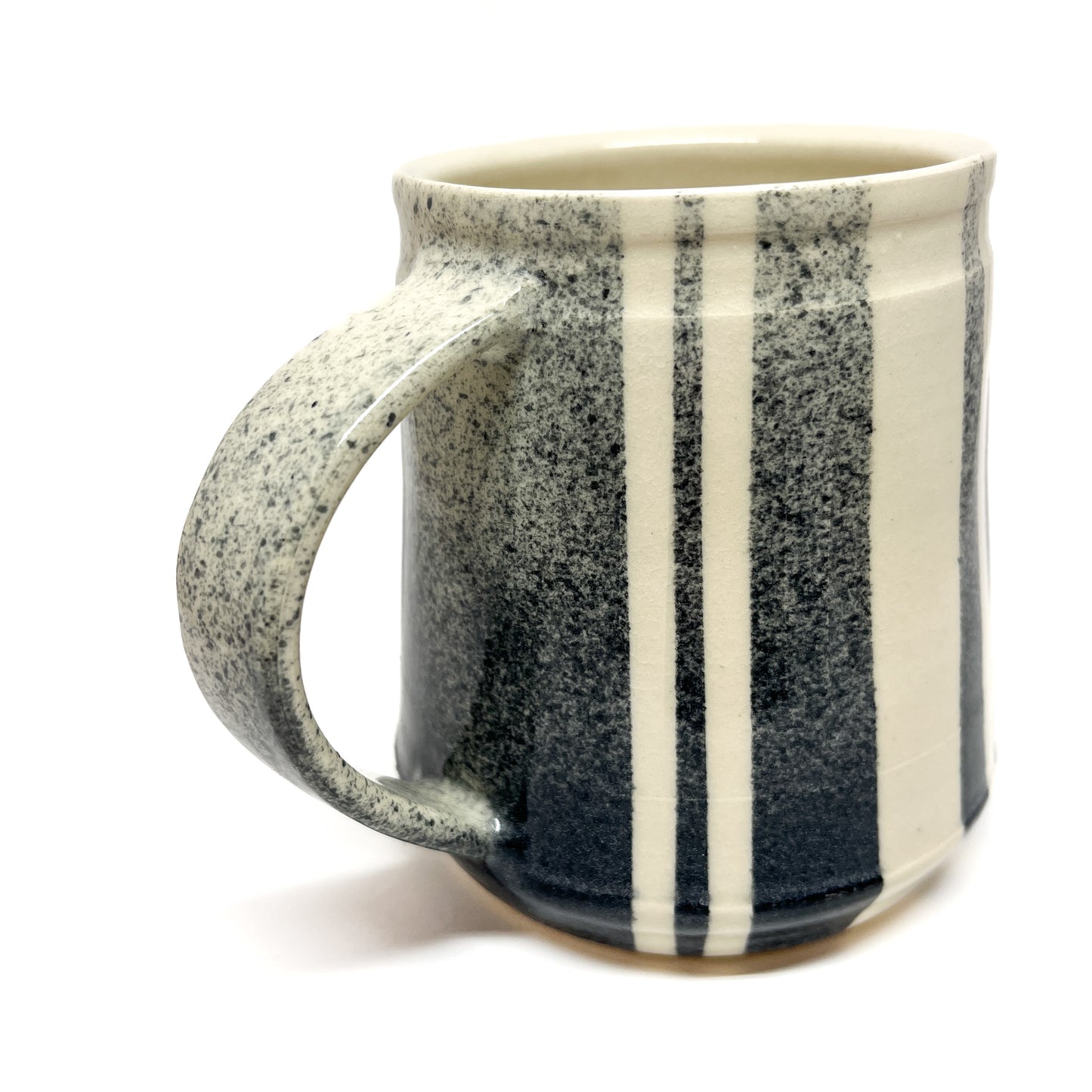 Striped ceramic mug with a handle, angled to the left, showing its side and interior rim.