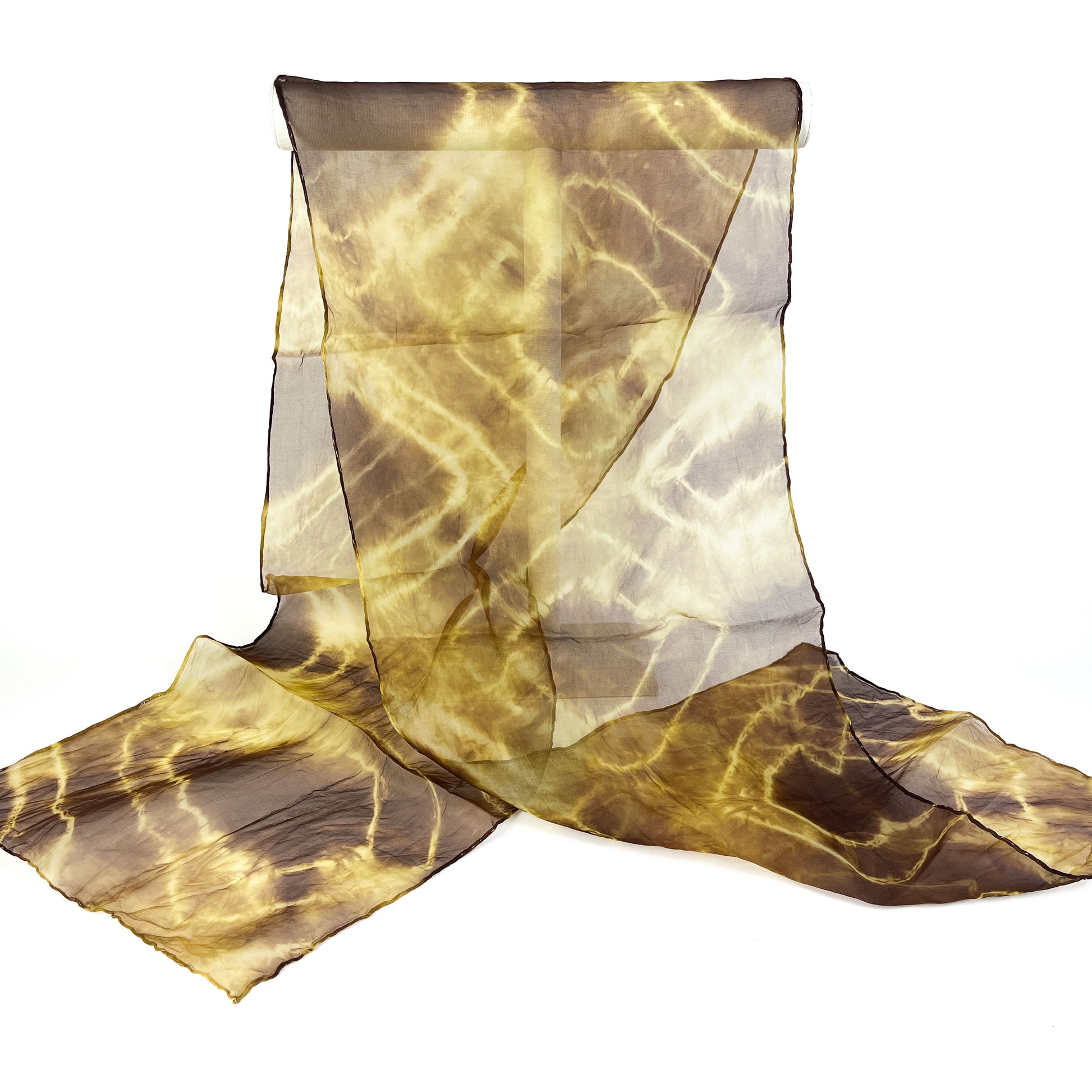 A sheer silk scarf with a dynamic, crackled tie-dye pattern in earthy tones is partially draped.