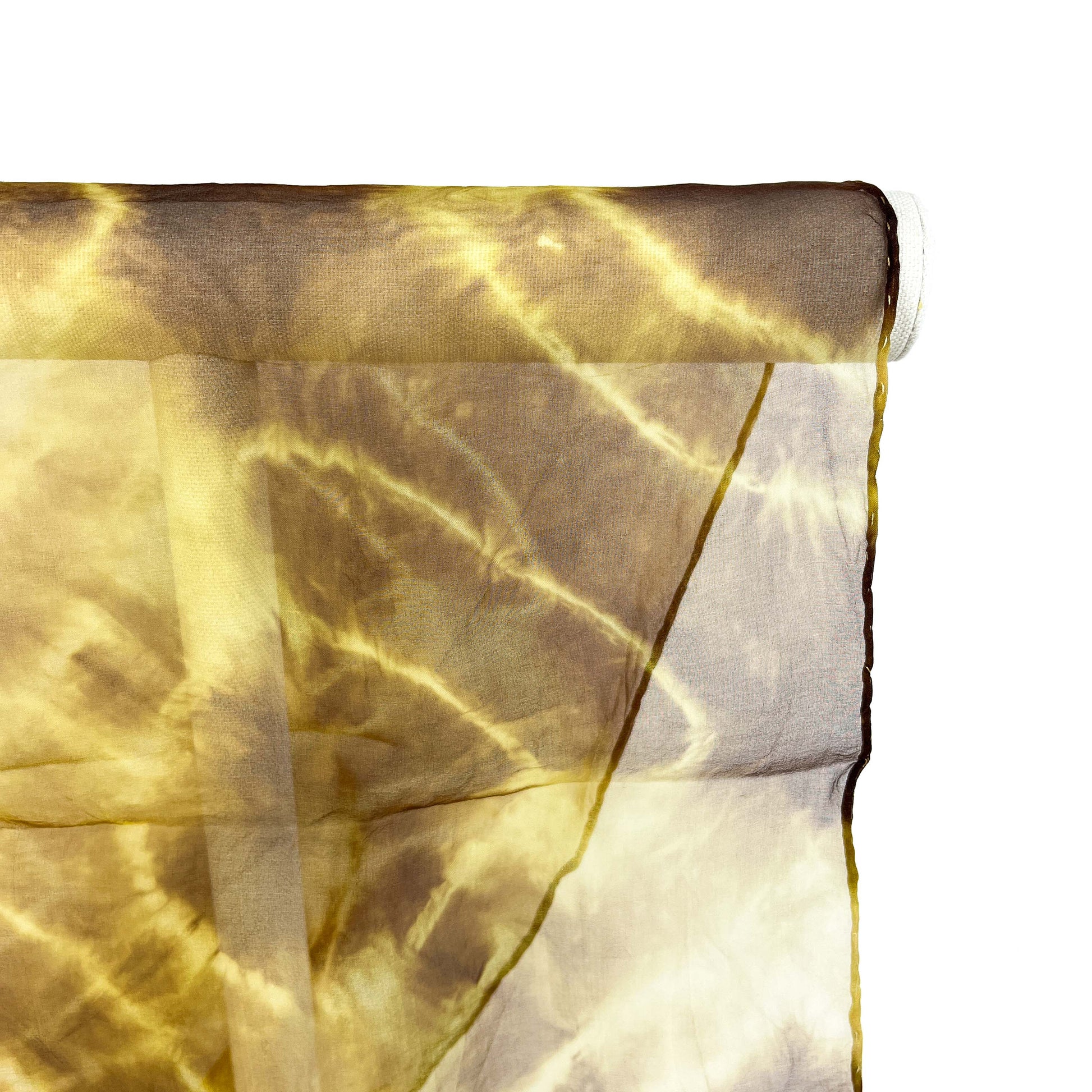 A close-up shows the delicate weave and crackled tie-dye pattern of a sheer silk scarf draped over a white bar.