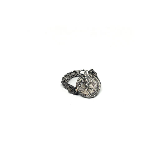 A silver ring featuring an embedded, aged coin with a figure and inscription, attached to a chain-link band.
