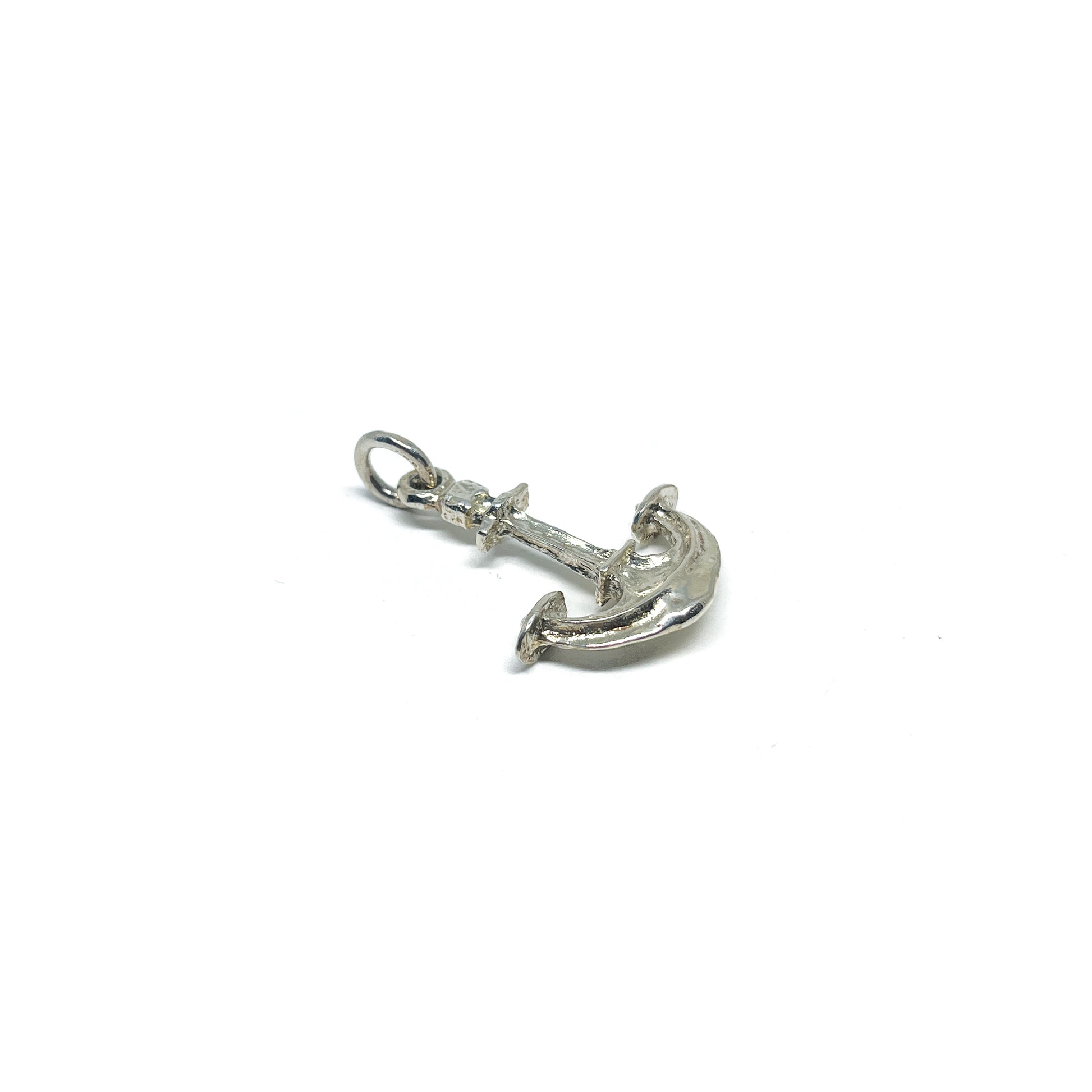A shiny, textured sterling silver anchor pendant with a small jump ring for attachment.