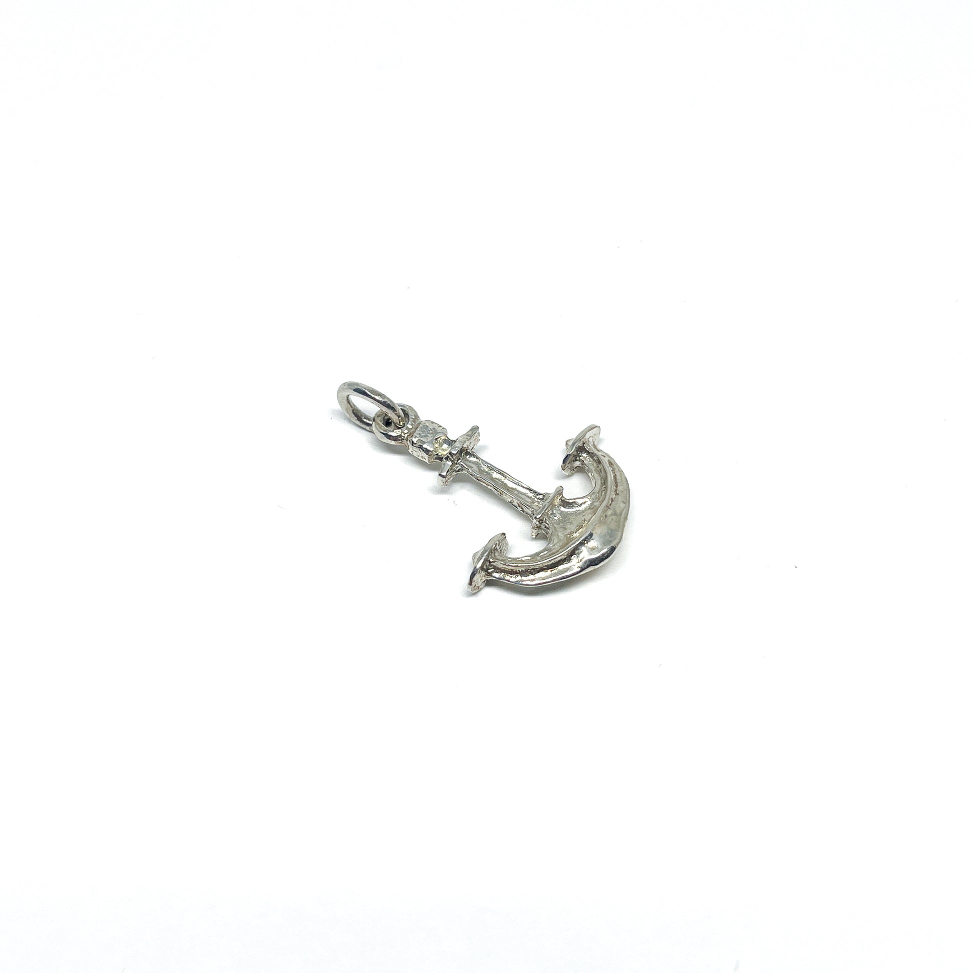 A detailed, shiny sterling silver anchor pendant with a small ring at the top for attaching to jewelry.