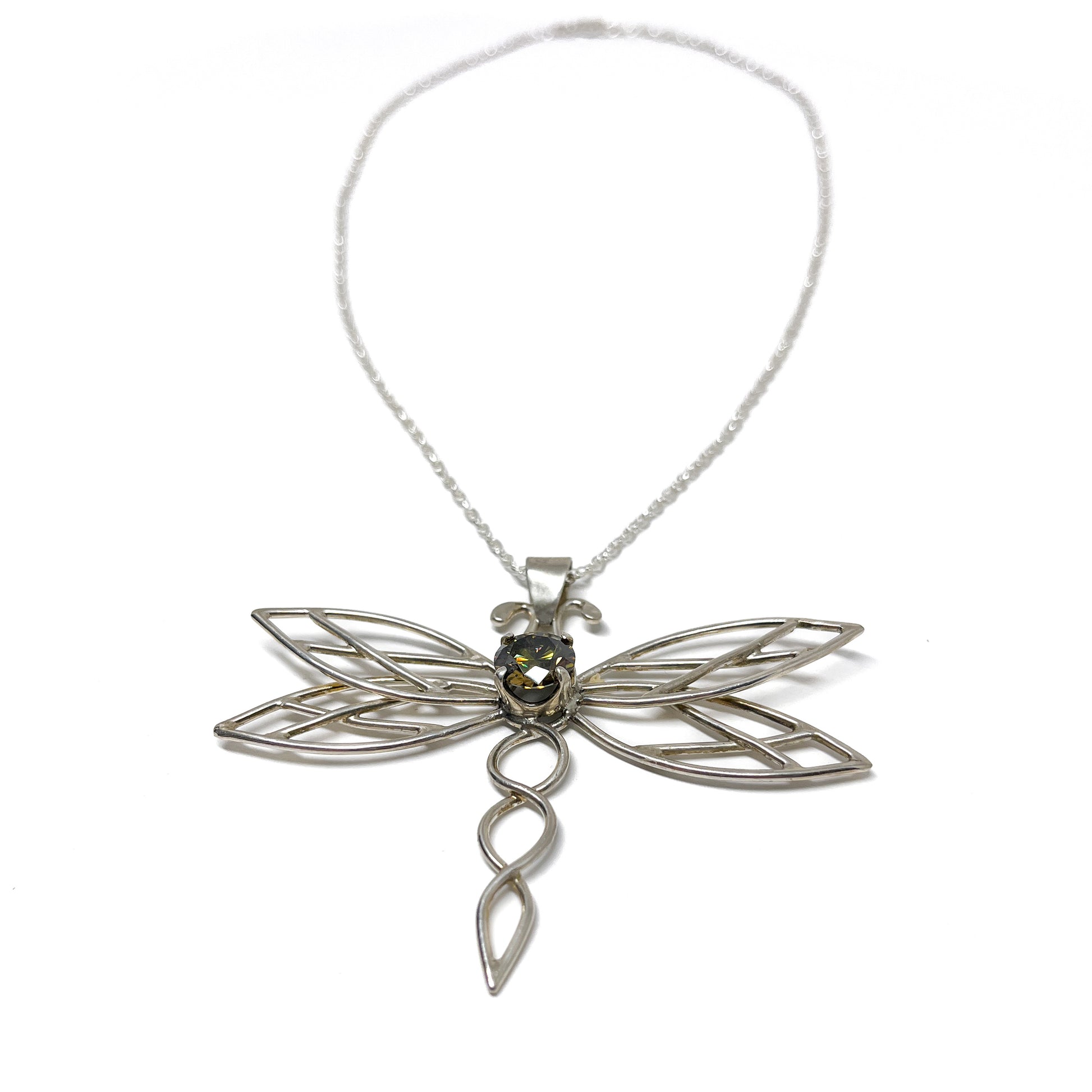 Detailed view of a silver dragonfly pendant necklace featuring a central dark gemstone.