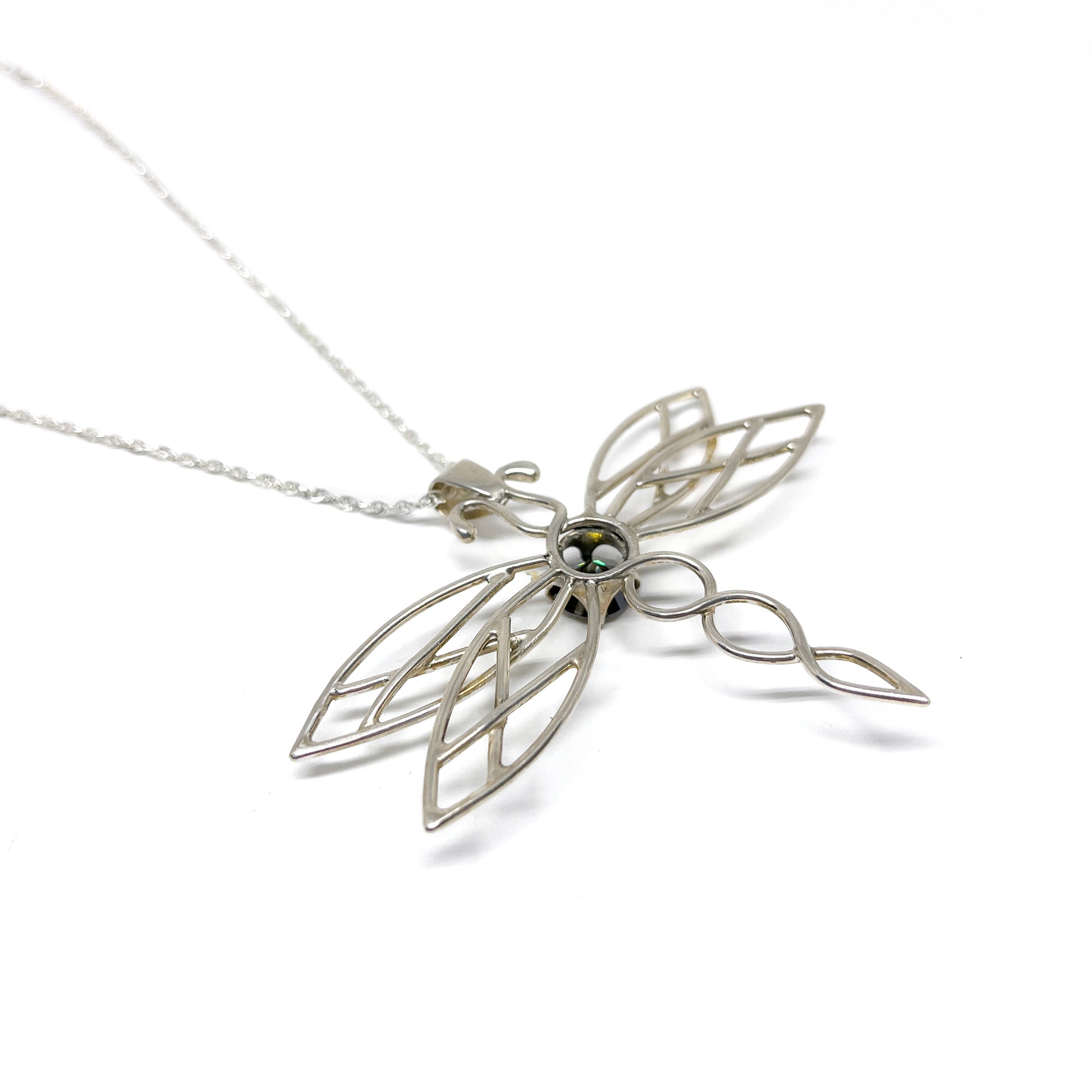 Close-up of a silver dragonfly pendant necklace highlighting its intricate wing design and gemstone.